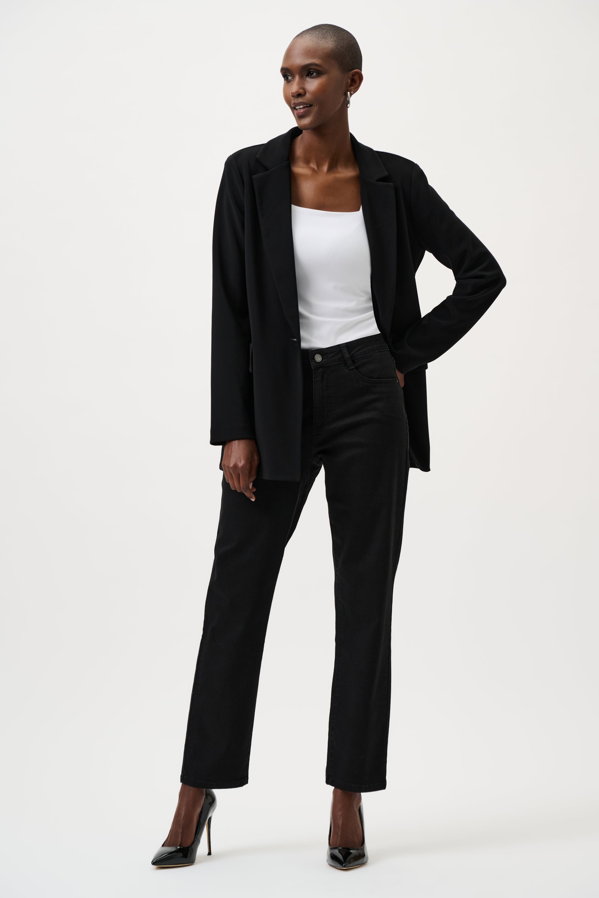 Person wearing a black suit with a white top on a white background