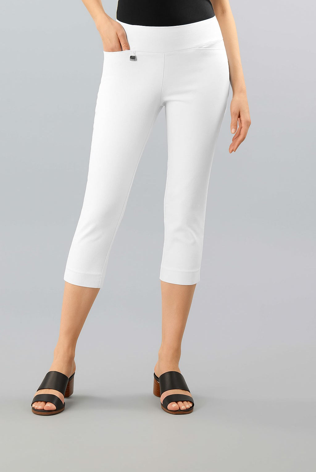 Person wearing white capri pants on a gray background