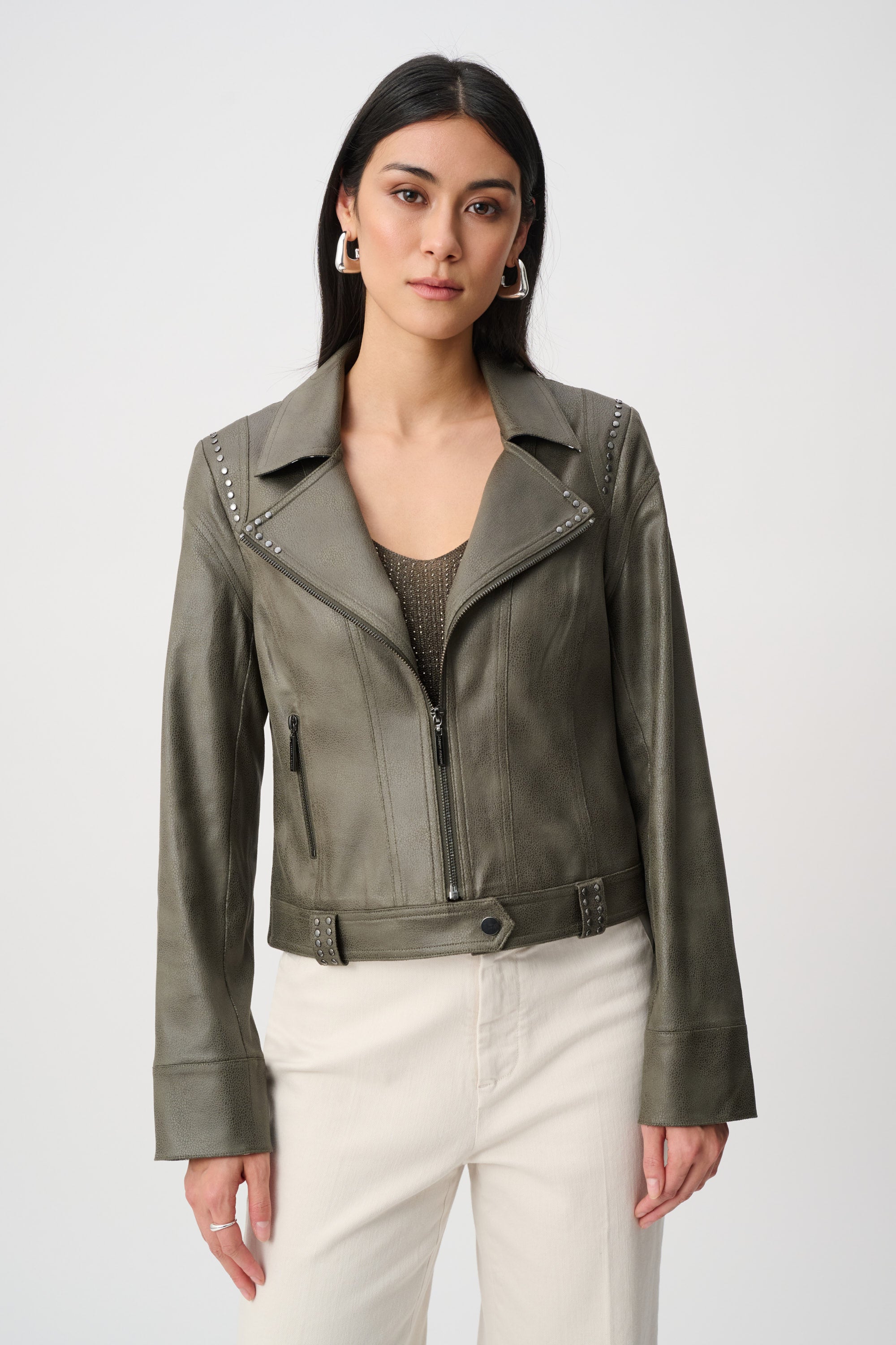 Woman wearing a green leather jacket on a white background