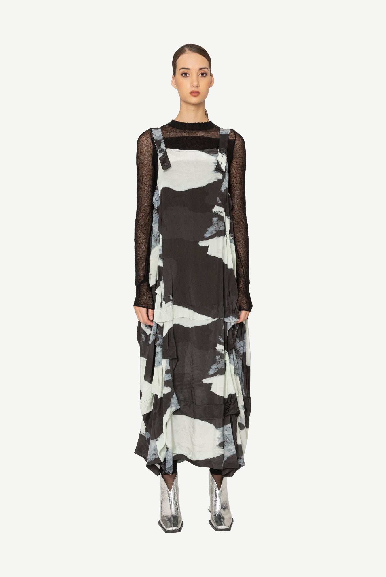 Model wearing a black and white patterned dress on a white background