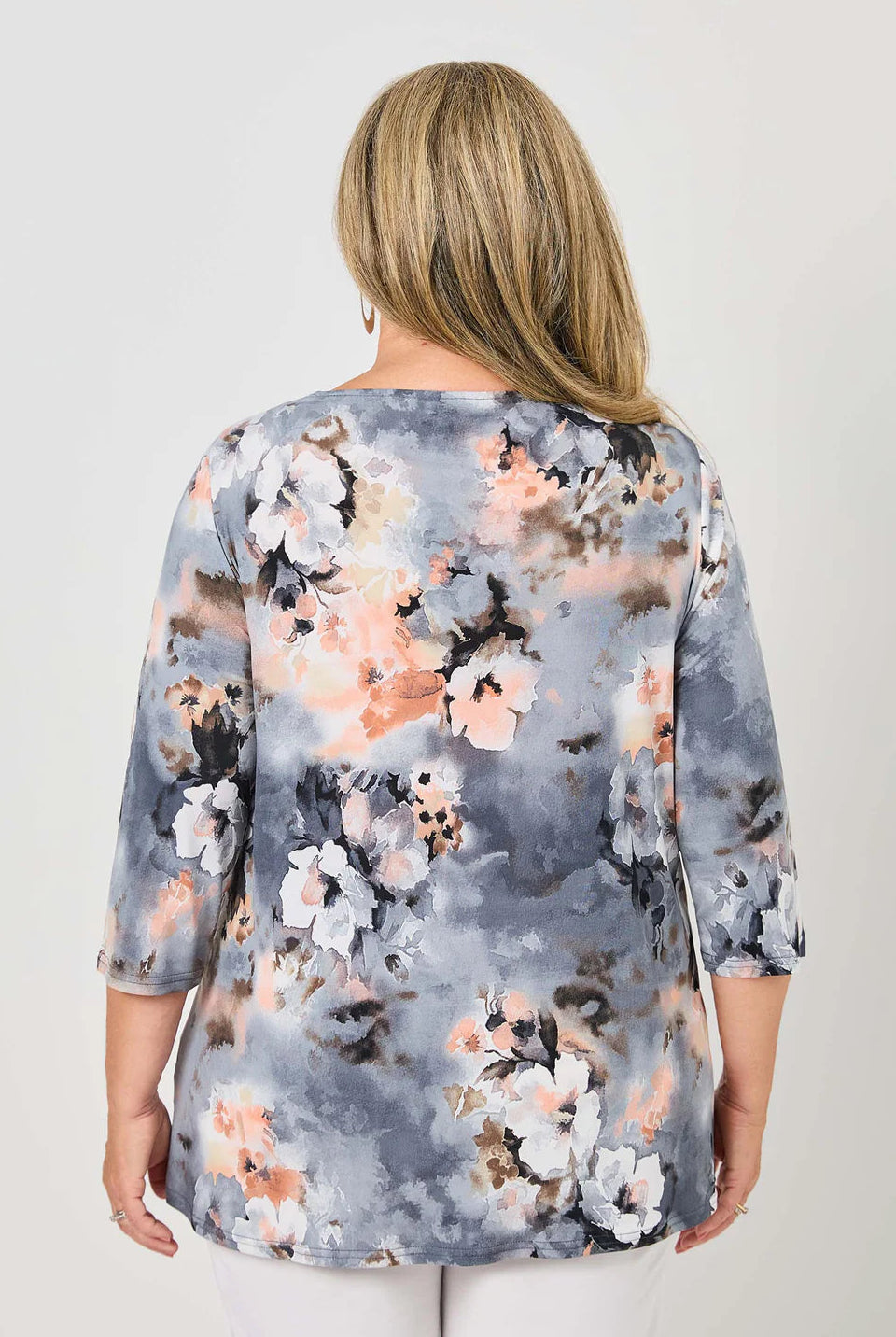 Woman wearing a floral blouse with a gray background