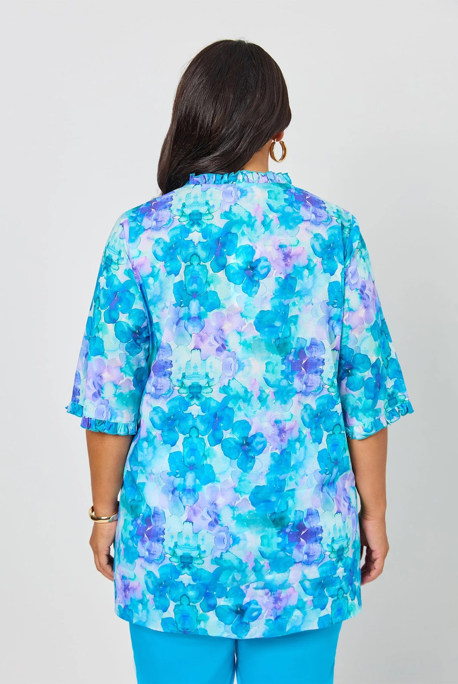 Woman wearing a blue floral blouse against a white background