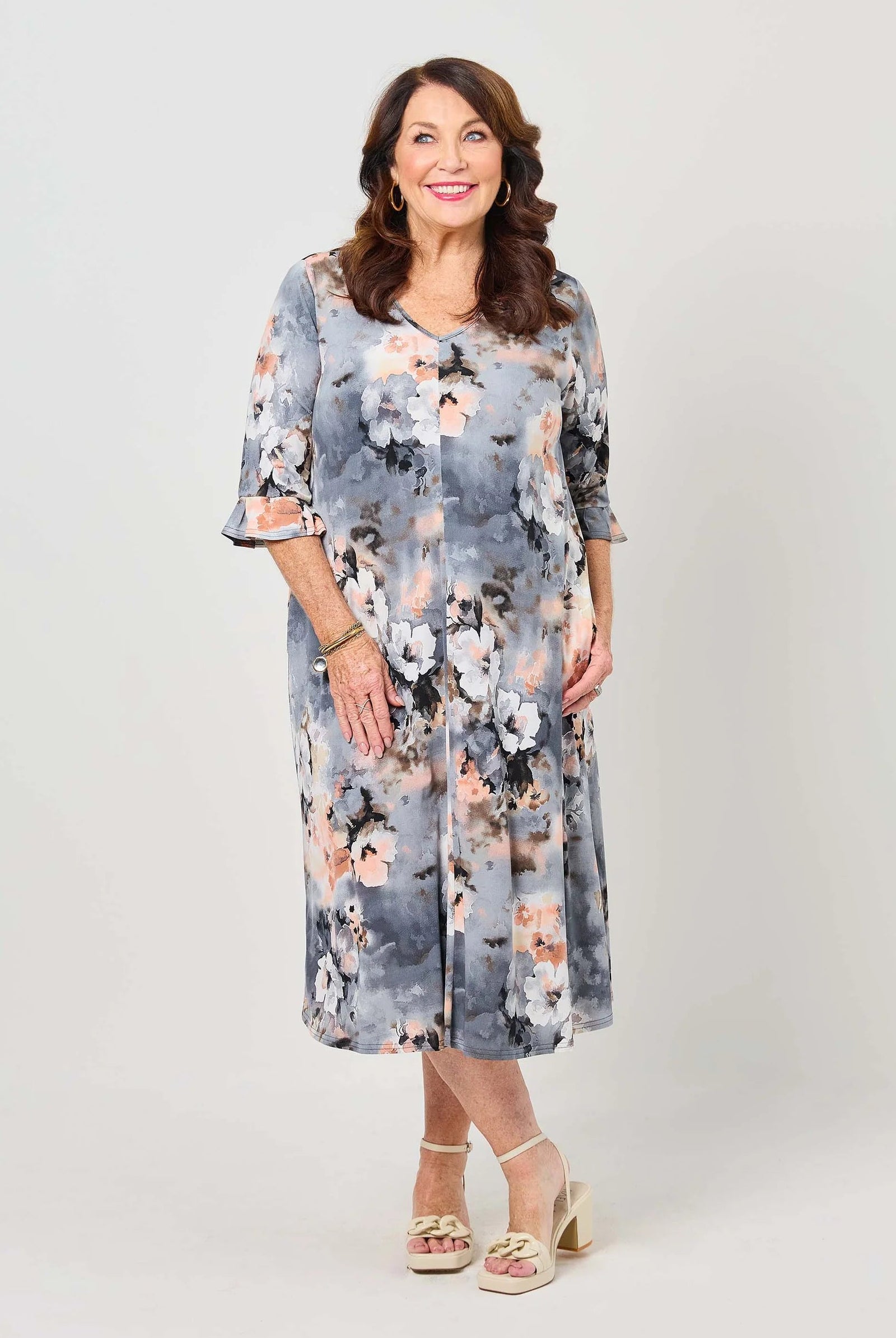 Woman wearing a floral dress on a plain background
