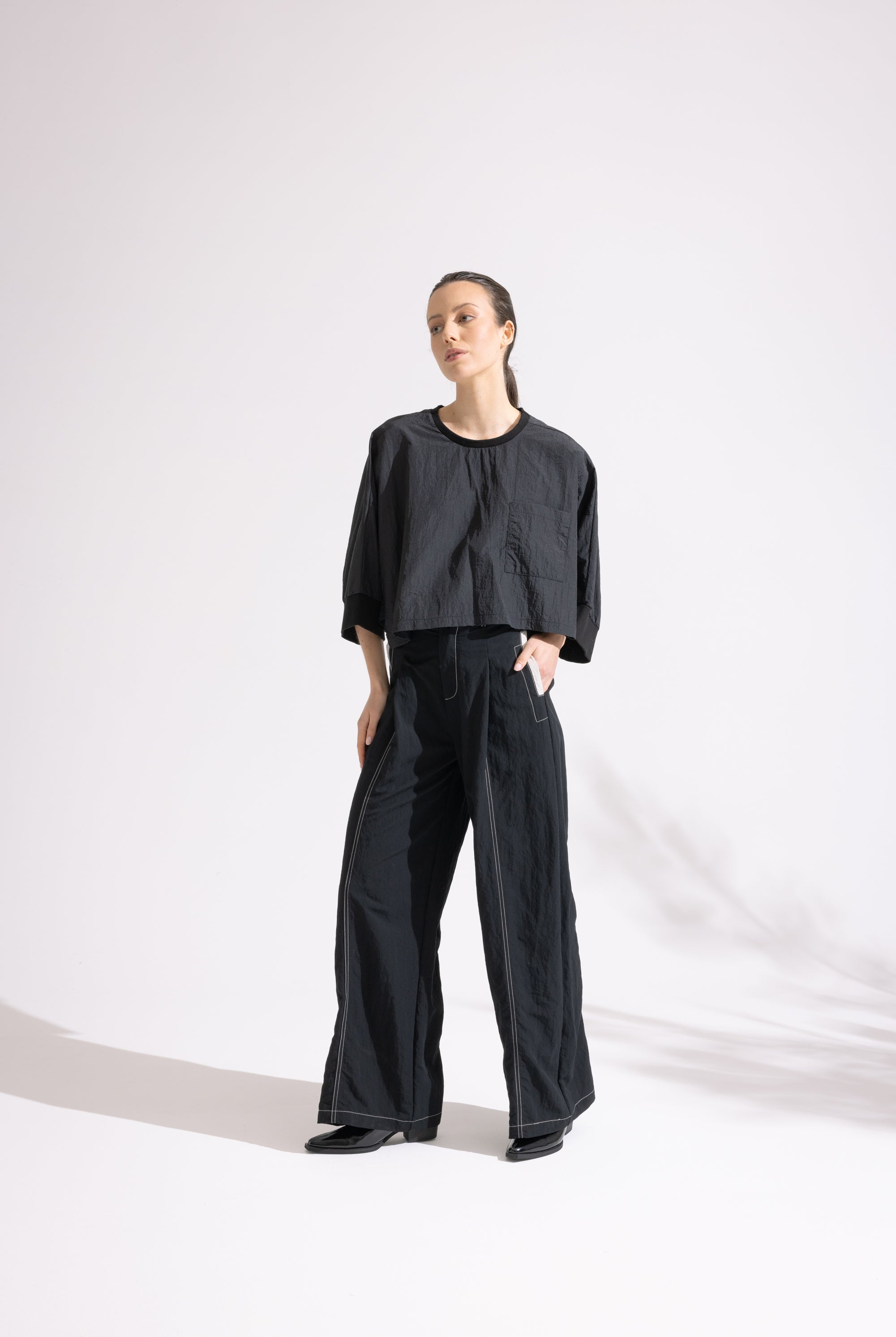 Person wearing a black outfit on a white background