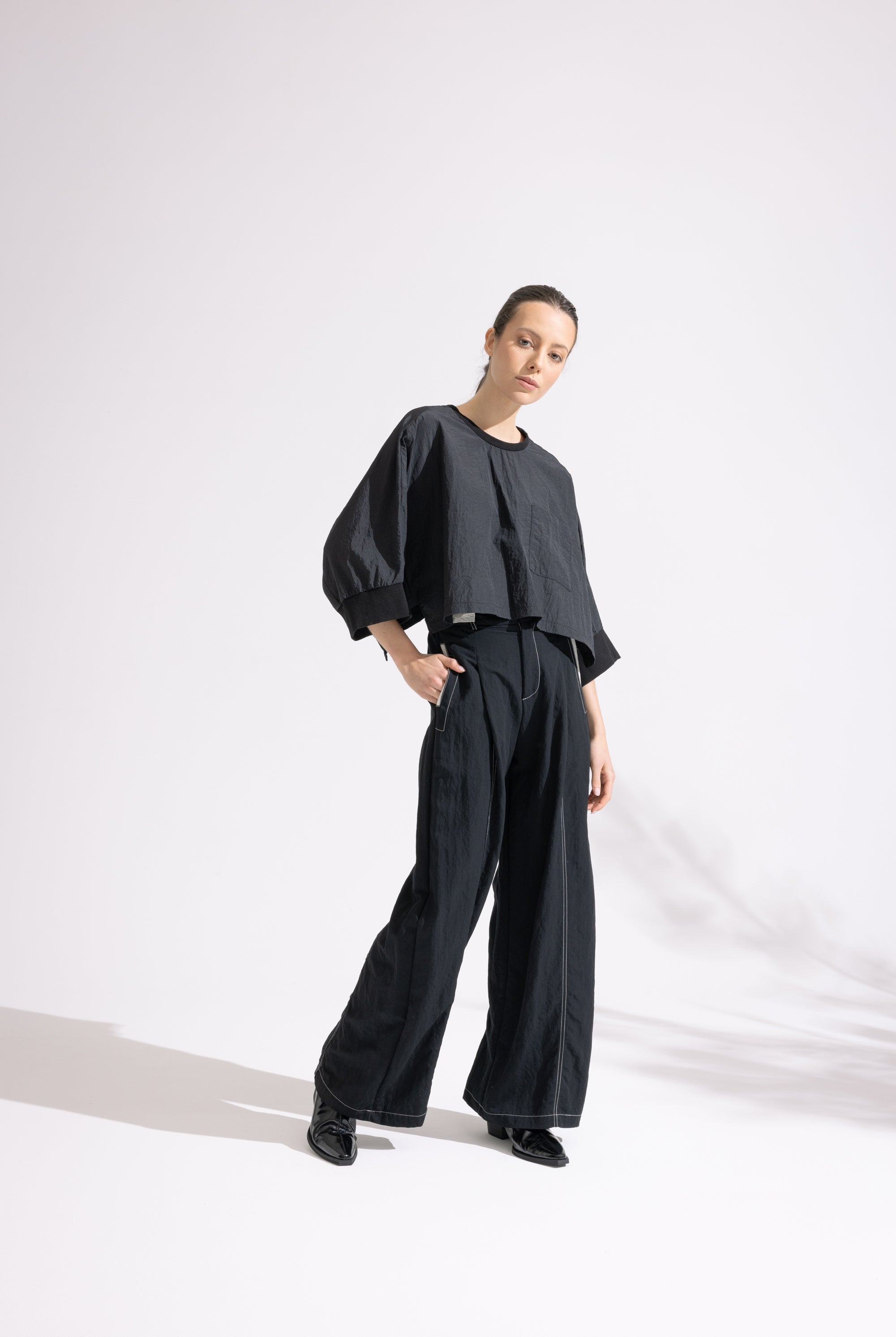 Person wearing a black outfit on a white background