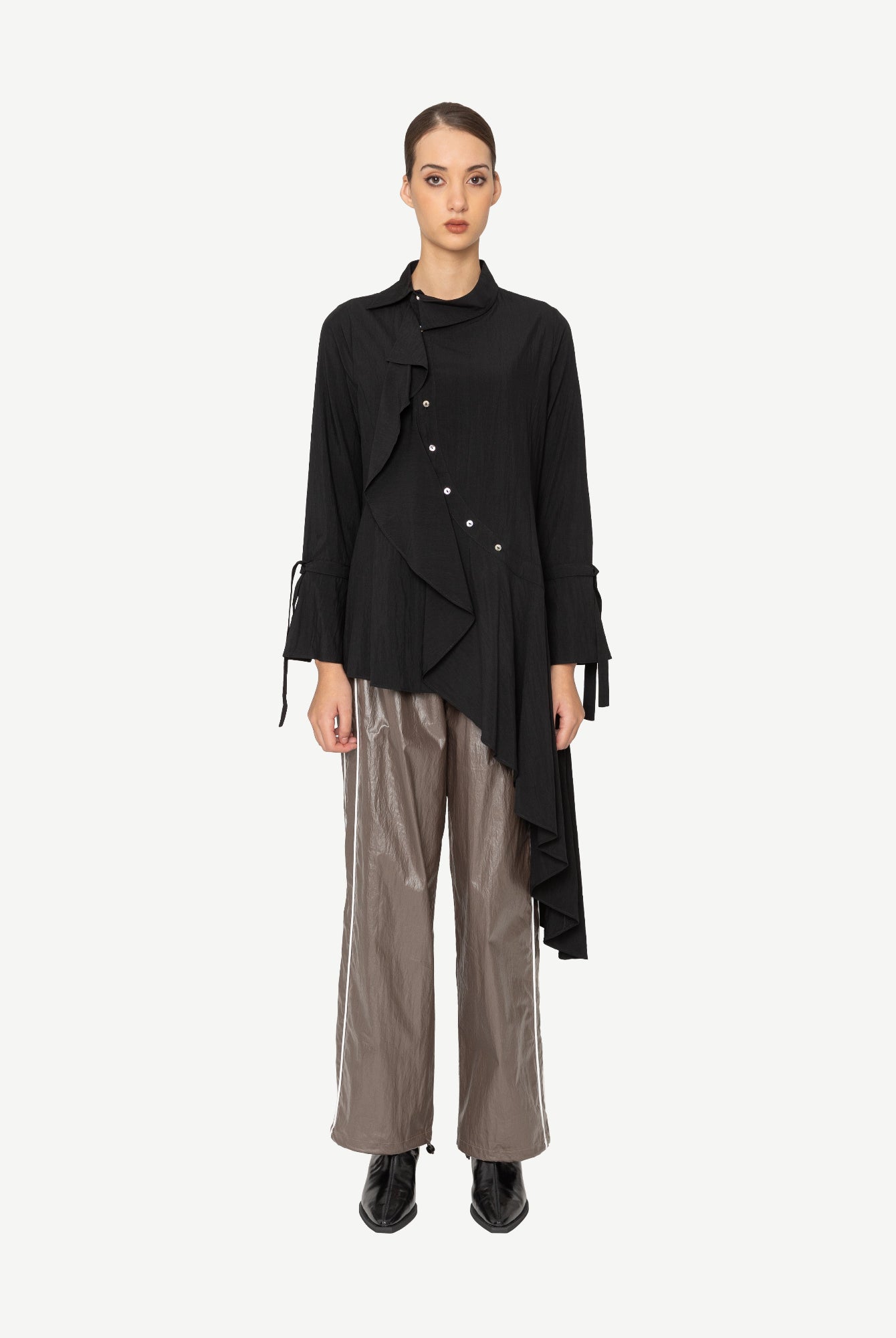 Woman wearing a black asymmetrical shirt with a white background