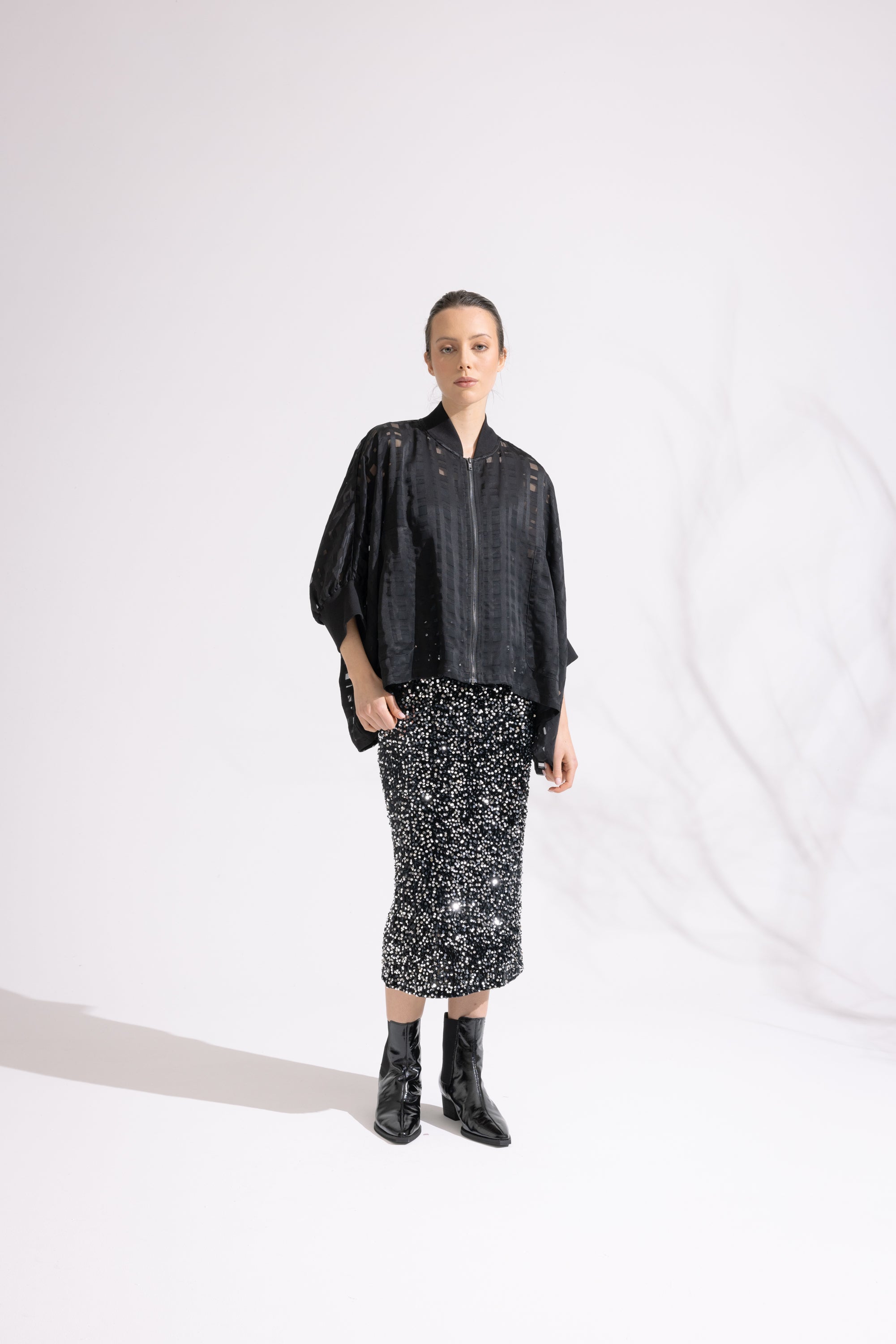 Person wearing a black patterned outfit on a white background