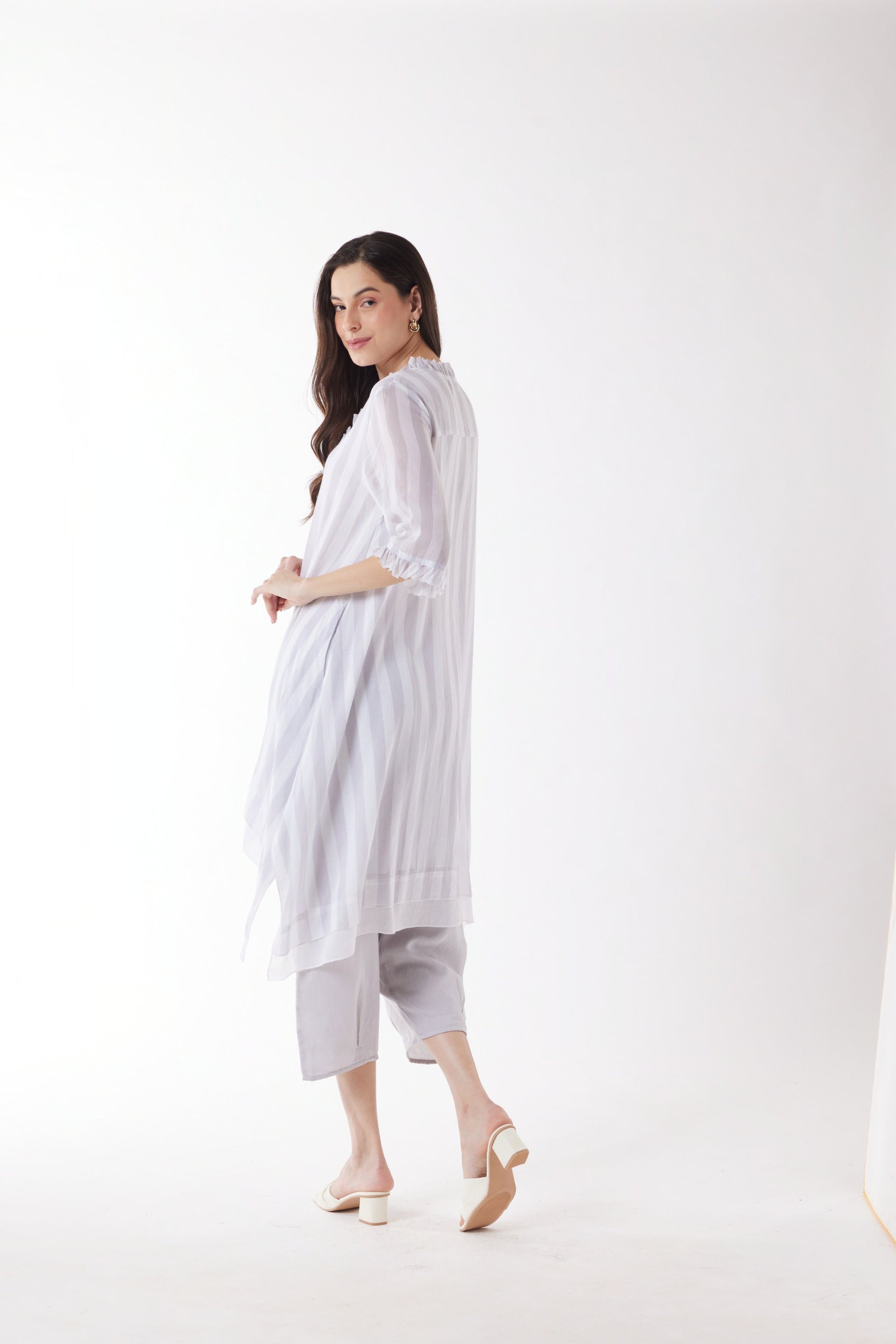 longline white grey stripe shirt and white pants worn by model back view