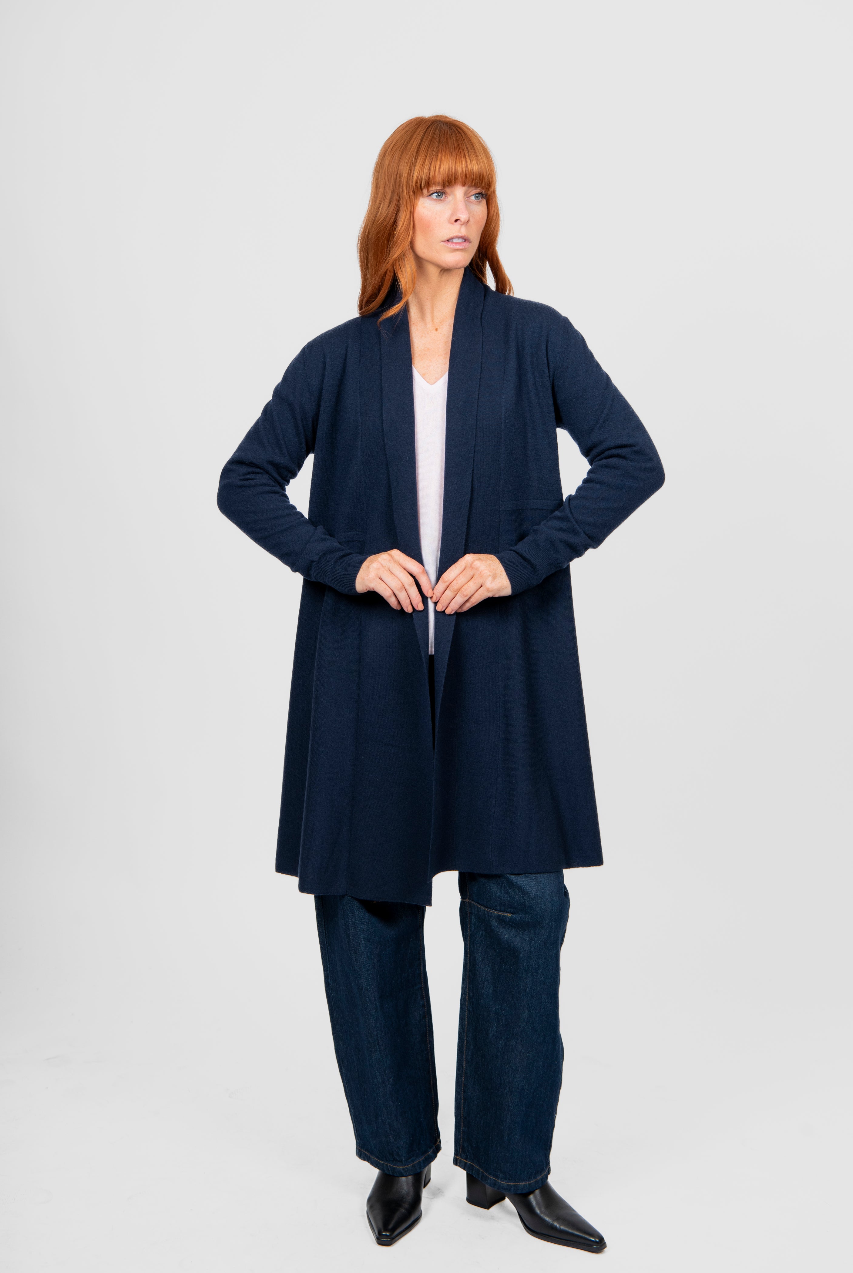 Woman wearing a navy blue cardigan and pants on a white background