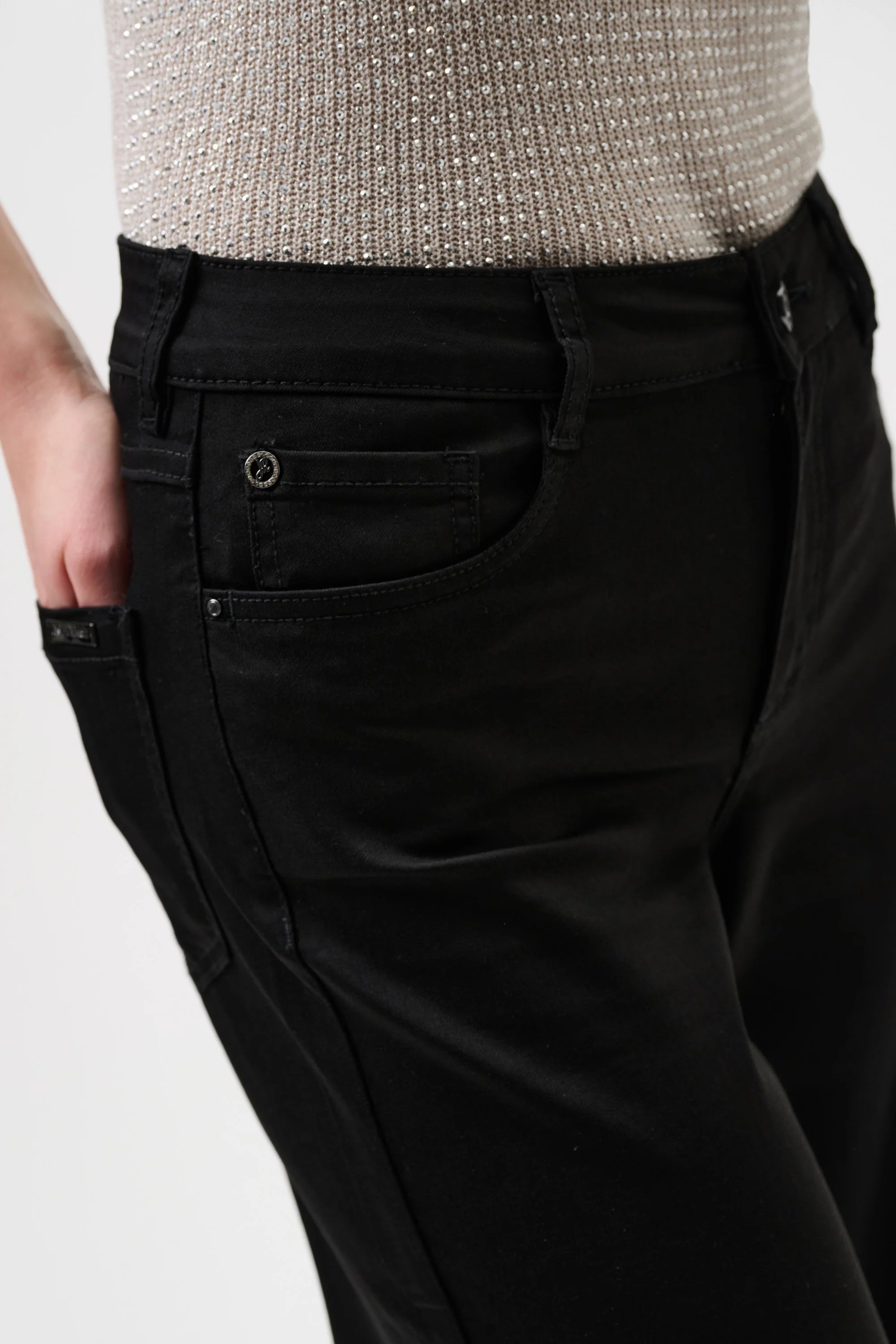 Black pants with a textured gray top on a white background close up