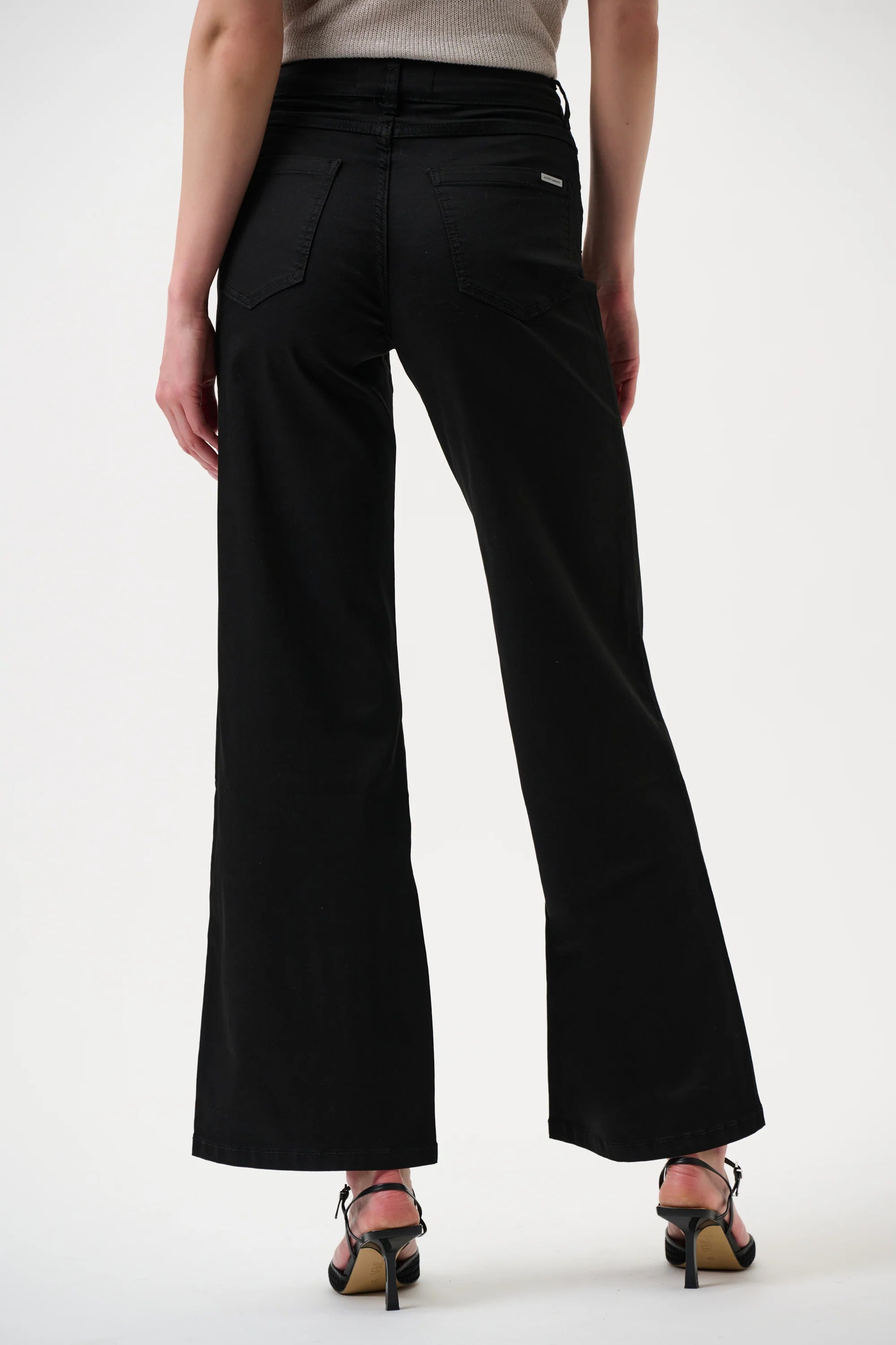 Black wide-leg jeans worn by a person on a white background back angle