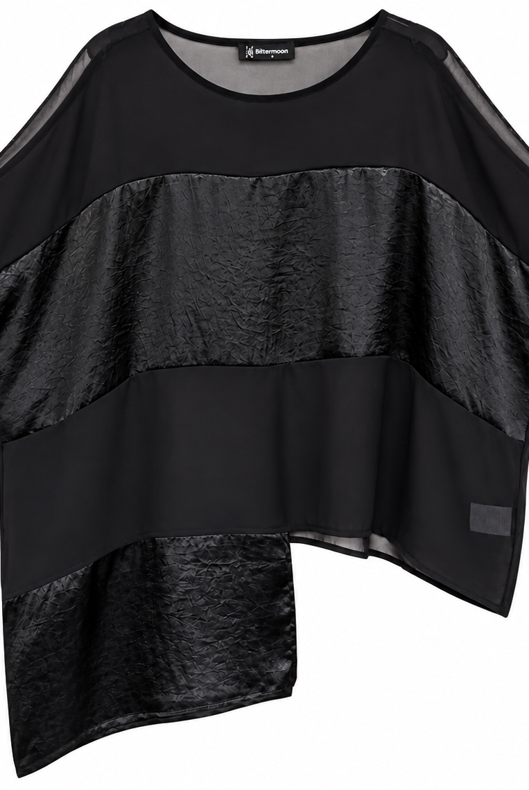 A black asymmetrical blouse with short sleeves, featuring a mix of sheer mesh and textured metallic fabric panels, shown on a plain white background.