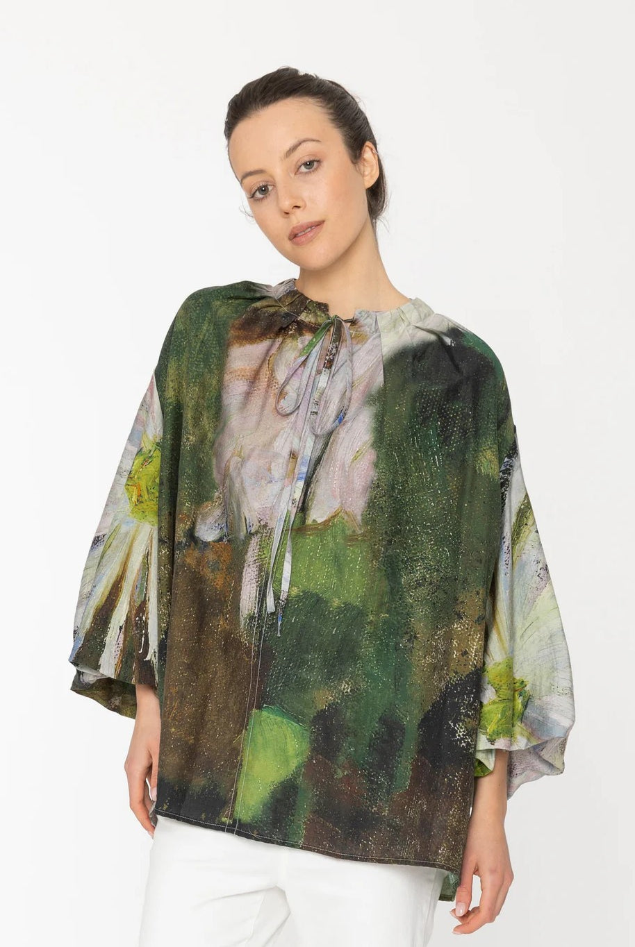 Woman wearing a colorful blouse with abstract design on a white background