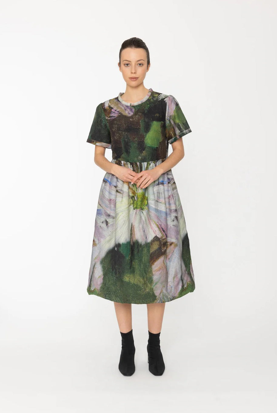 Model wearing a colorful dress with abstract patterns on a white background