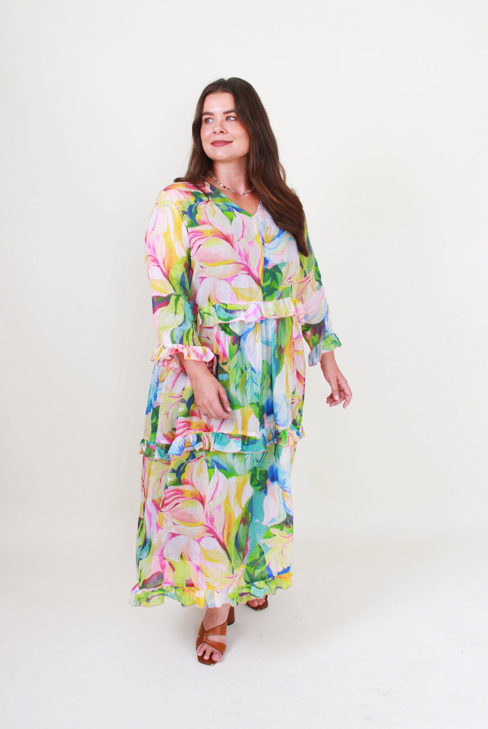 Woman wearing a colorful floral dress on a white background