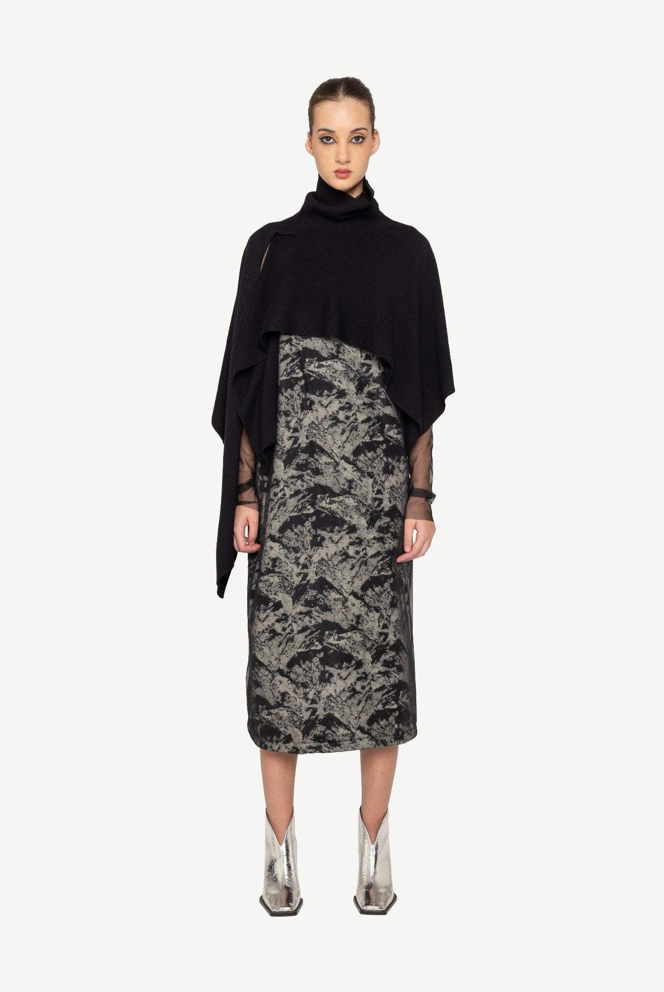 Woman wearing a black top and patterned skirt on a white background