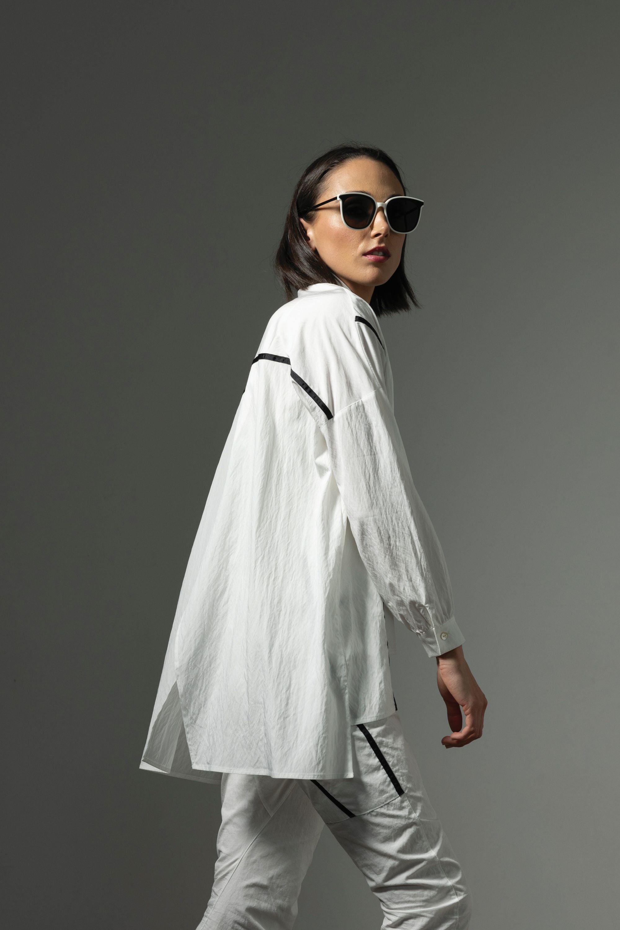 button through step hem shirt white with black details and white pant worn by model side view