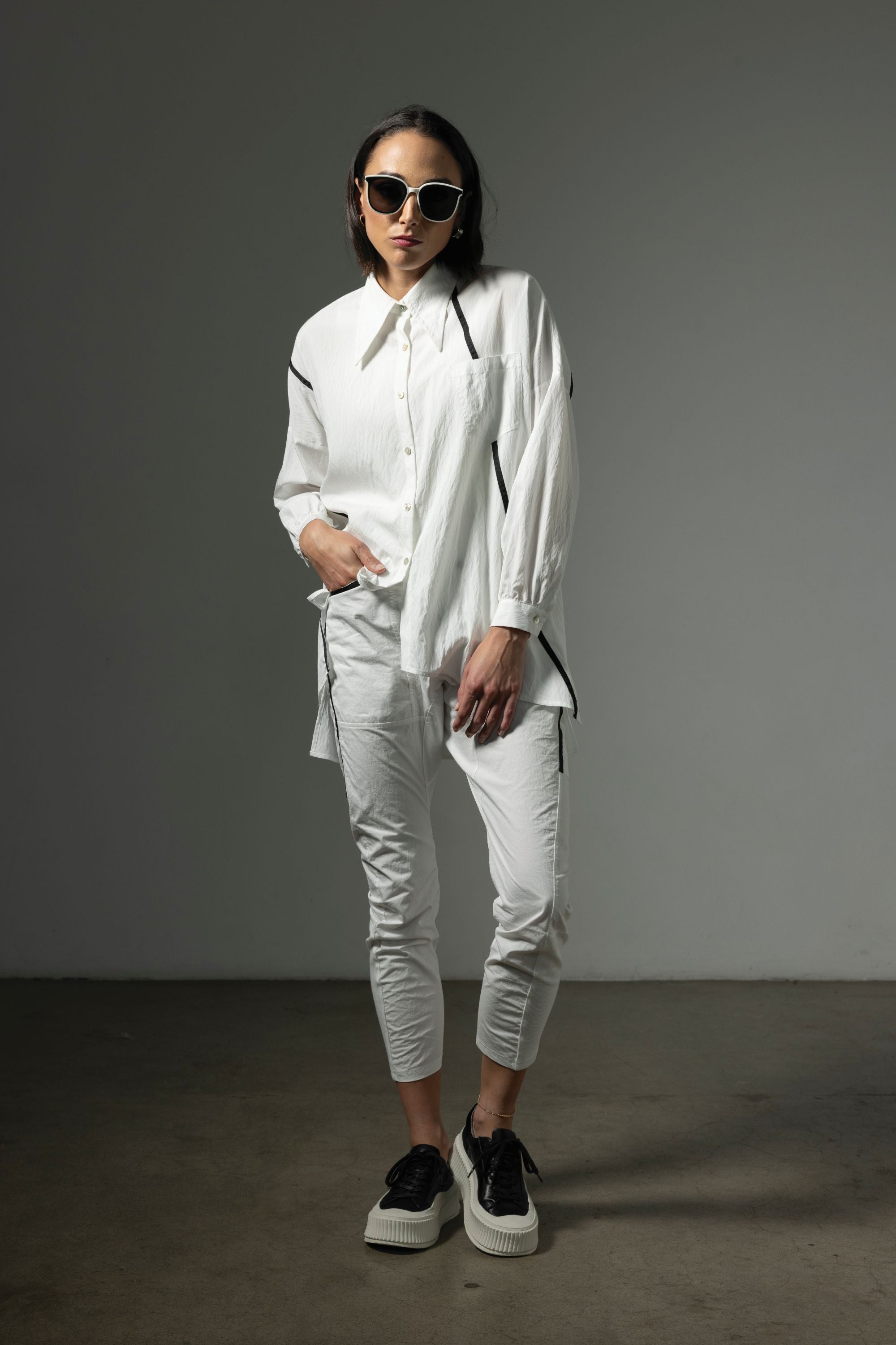 button through step hem shirt white with black details and white pant worn by model