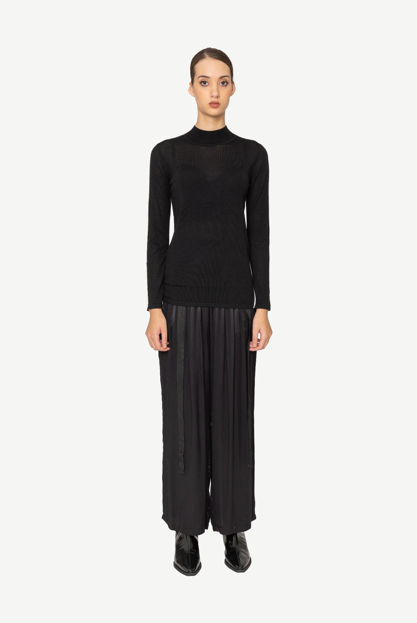 Person wearing a black outfit on a white background