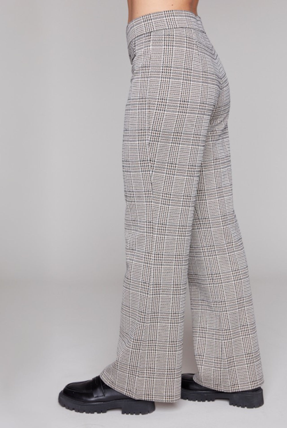 Plaid pants worn by a person on a plain grey background side angle
