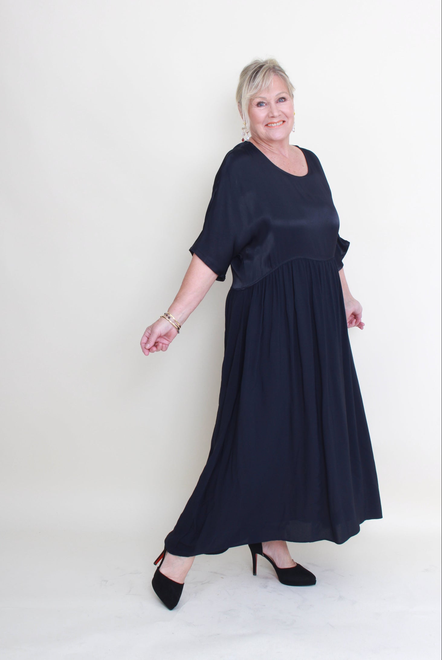 Woman wearing a long dark blue dress on a white background