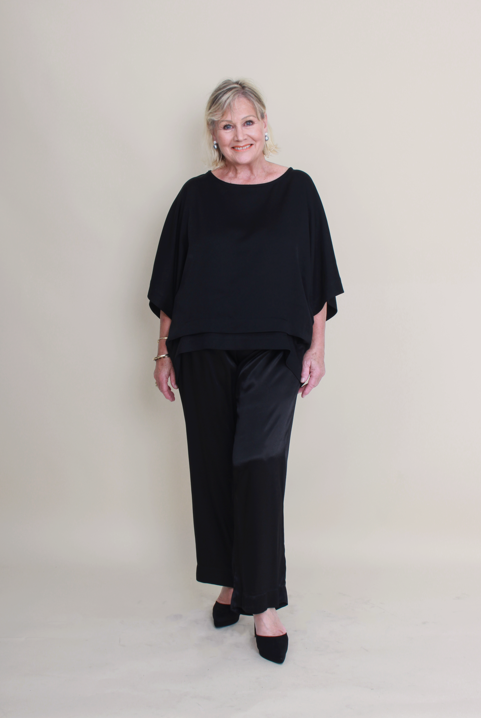 Woman wearing a black outfit against a plain background