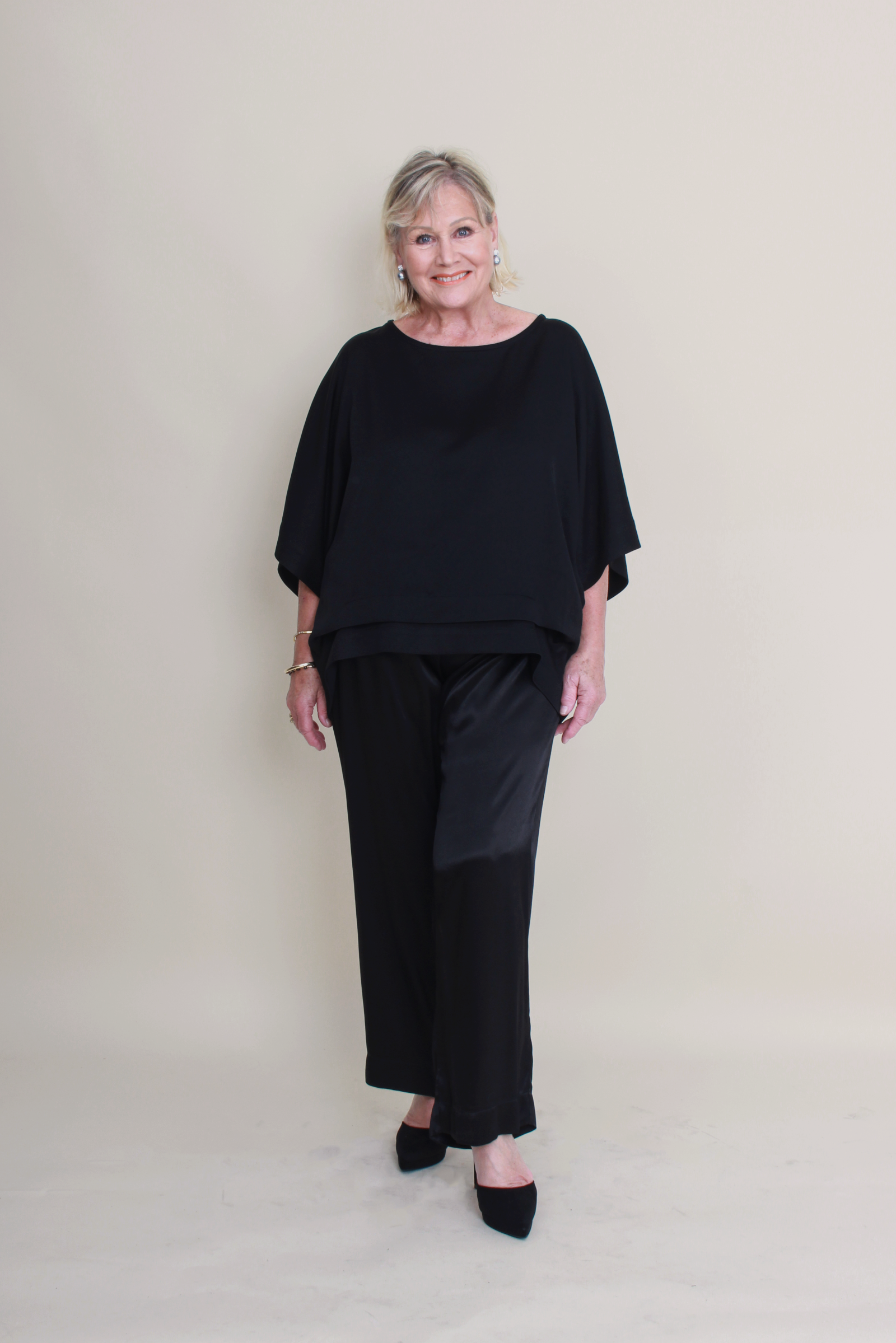 Woman wearing a black outfit against a plain background