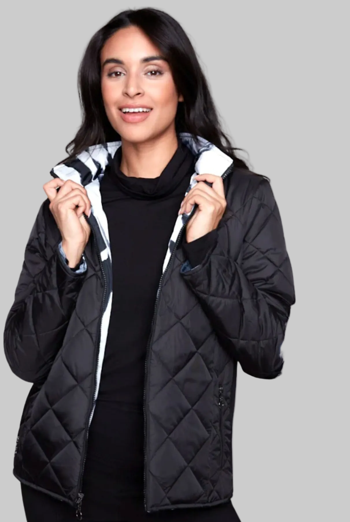 Woman wearing a black quilted jacket on a white background