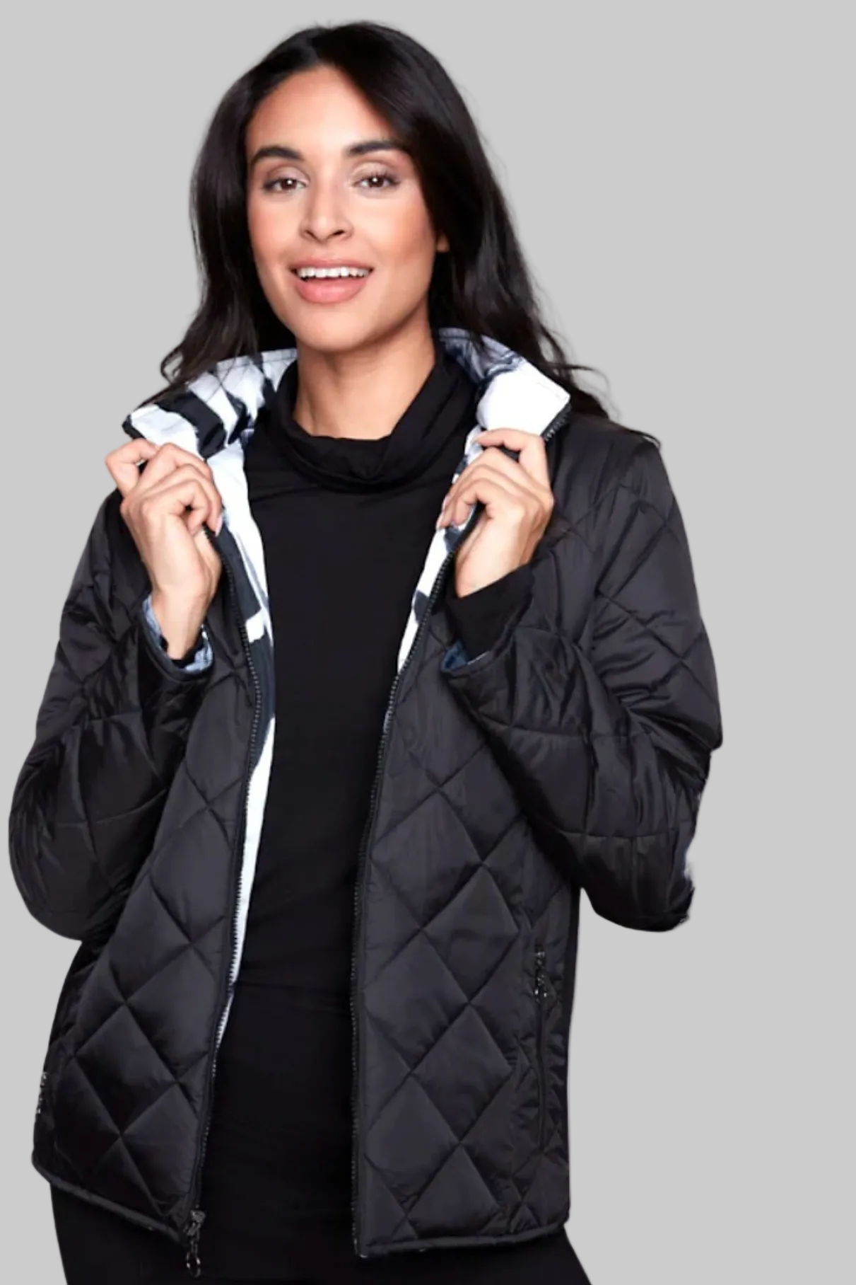Woman wearing a black quilted jacket on a white background