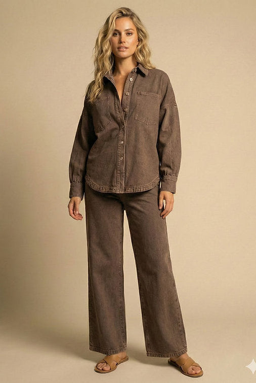 A woman modeling a matching two-piece lounge set consisting of a brown button-down shirt and wide-leg pants, styled with brown sandals against a solid beige studio background.