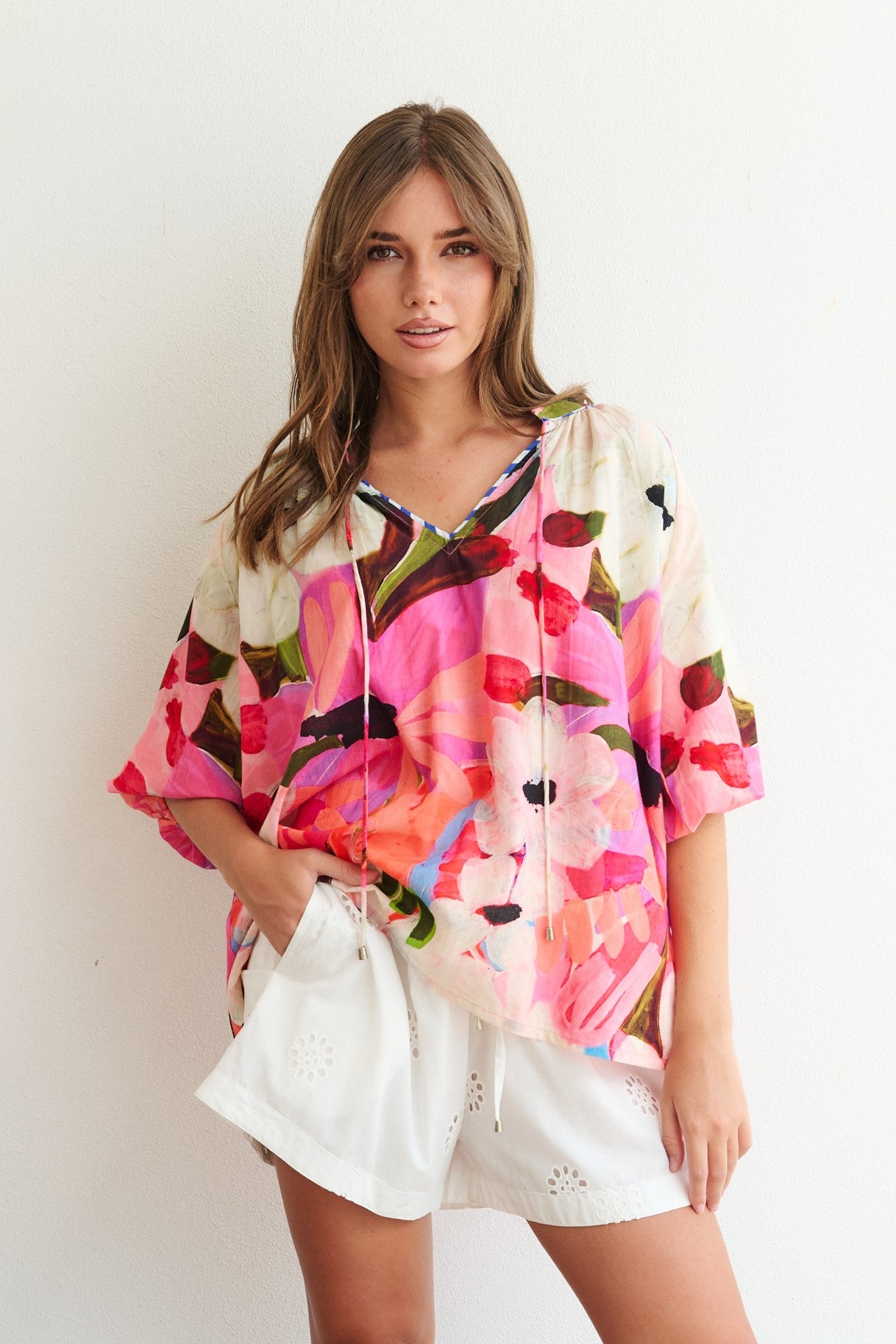 womens pink floral blouse and white shorts worn by model