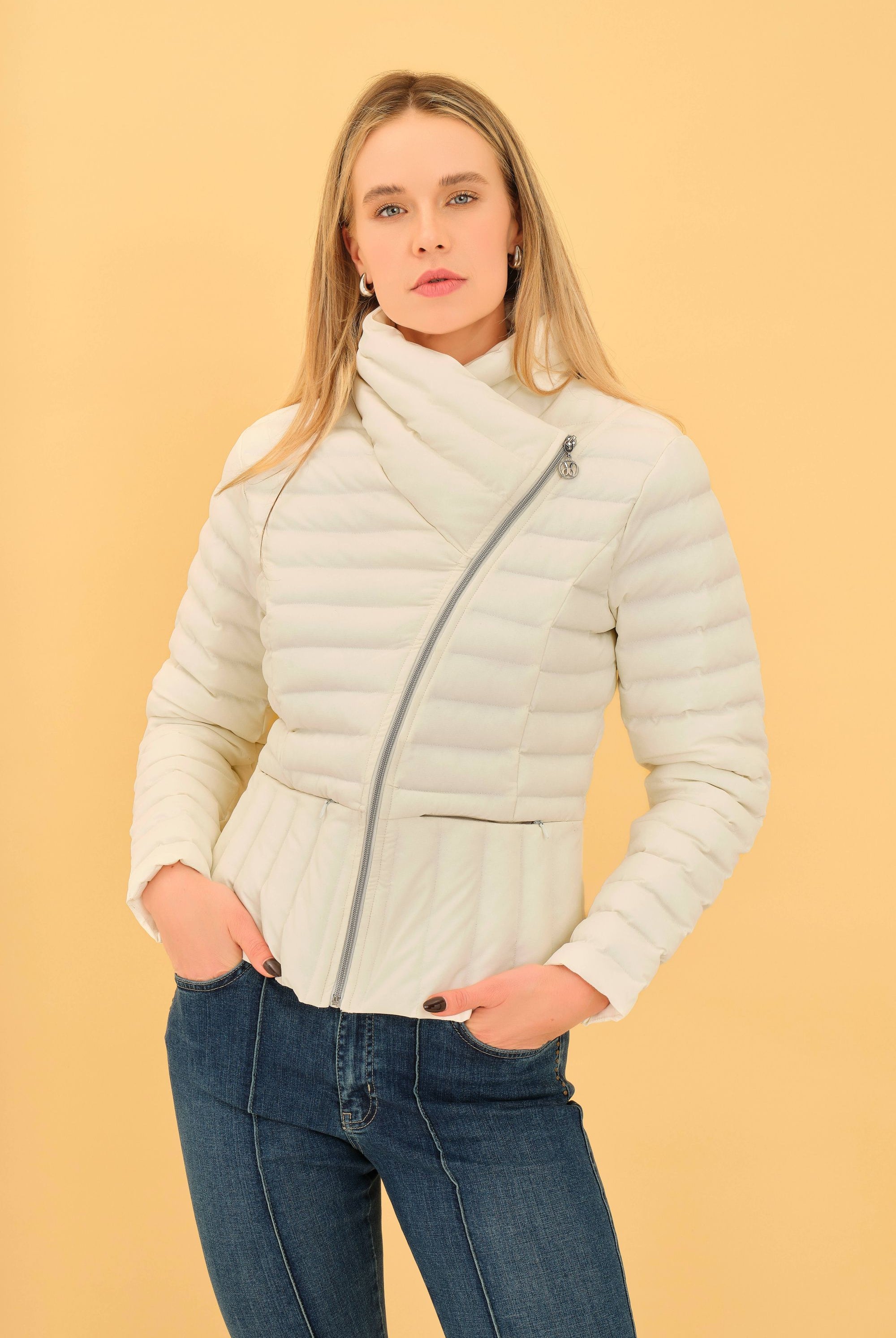 Woman wearing a light-colored puffer jacket against a yellow background