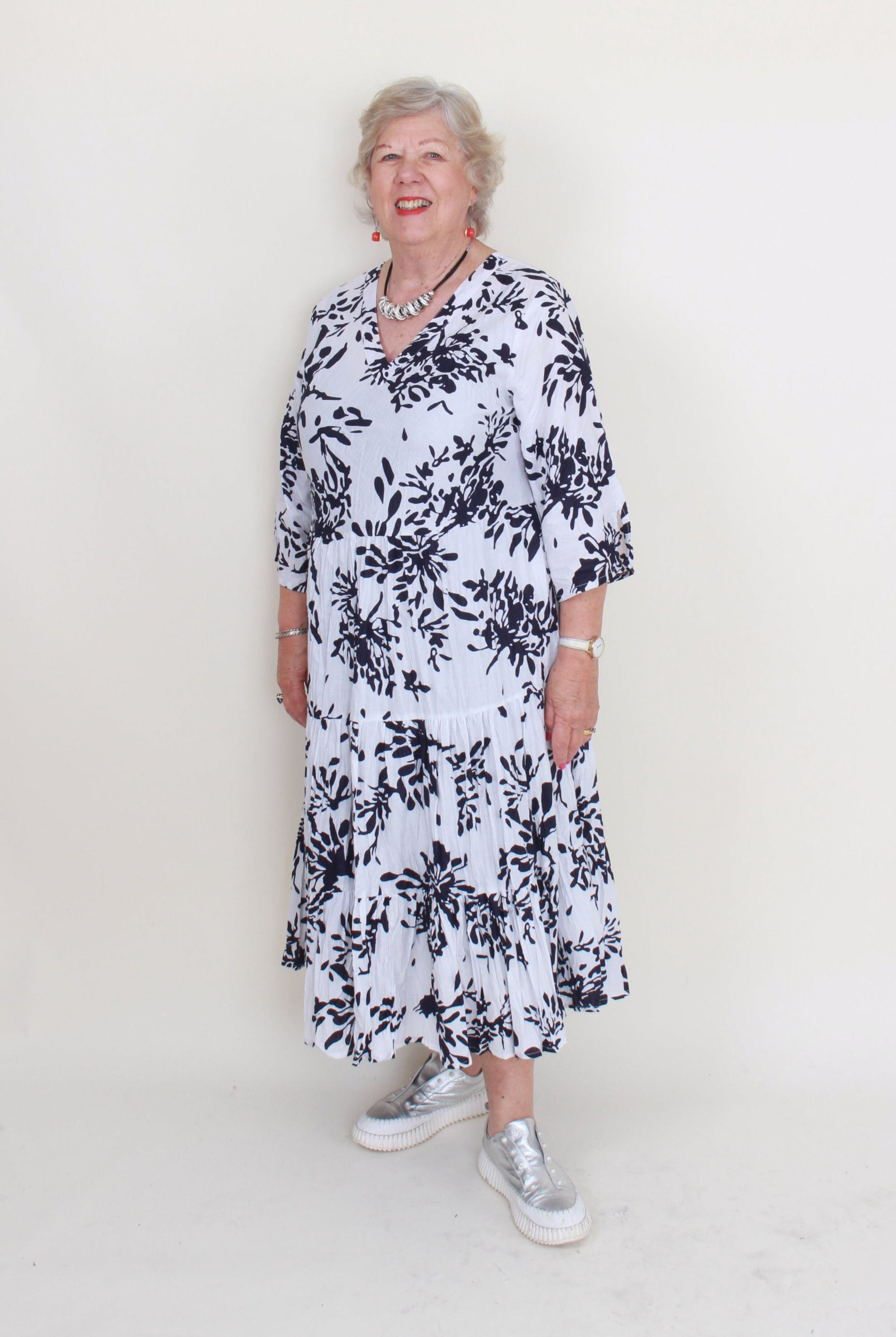 Woman wearing a black and white floral dress on a white background