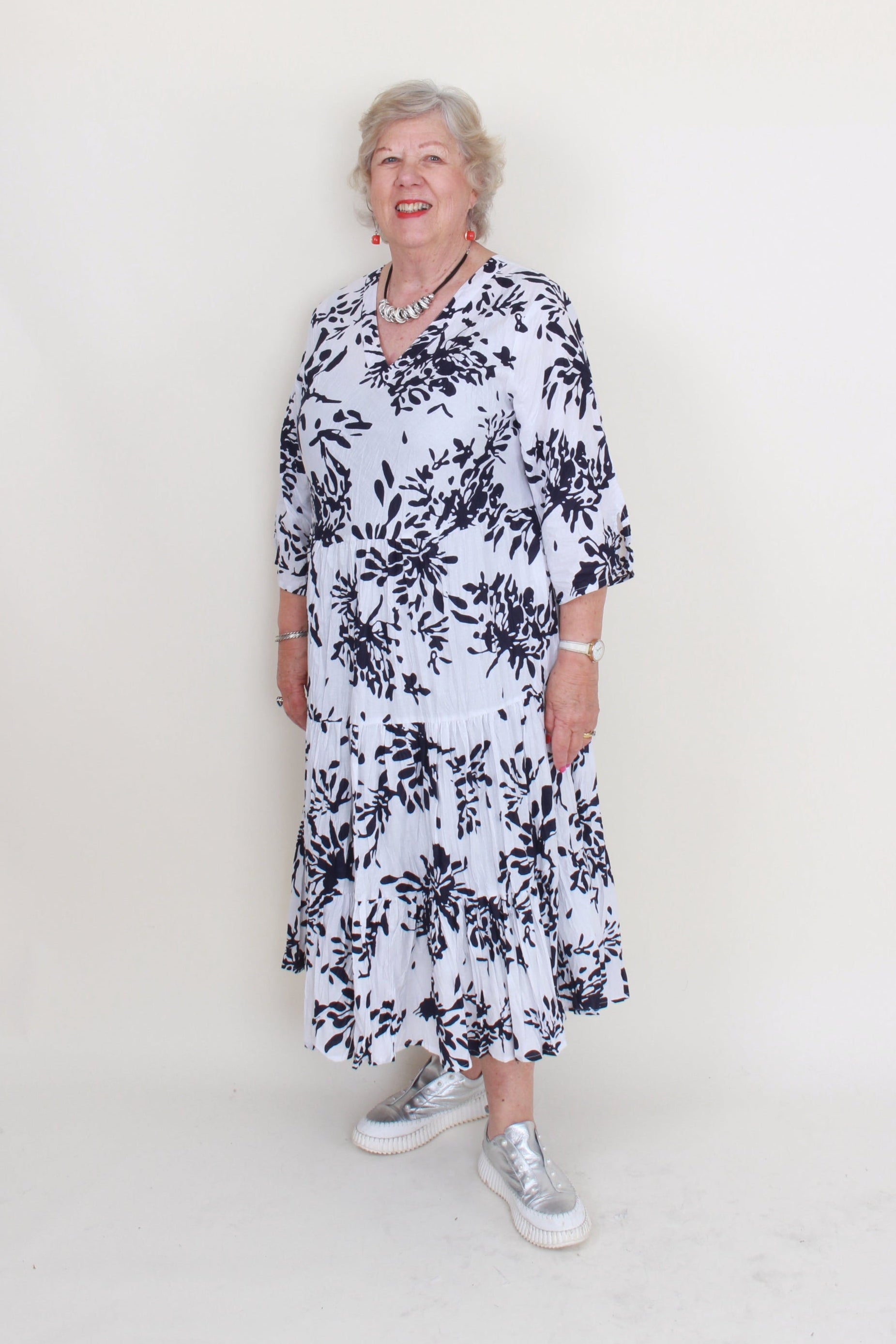 Woman wearing a black and white floral dress on a white background