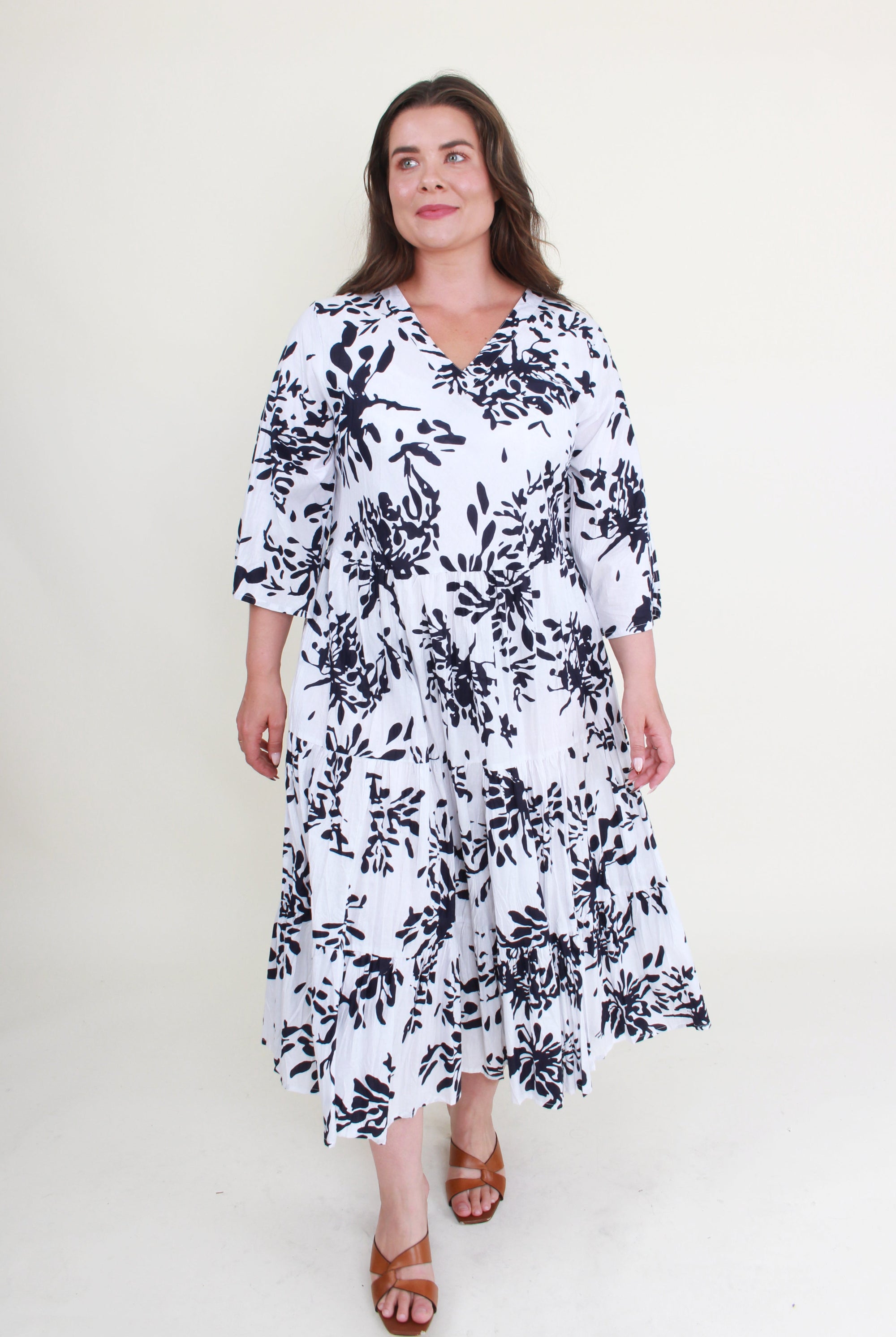 Woman wearing a black and white floral dress on a white background