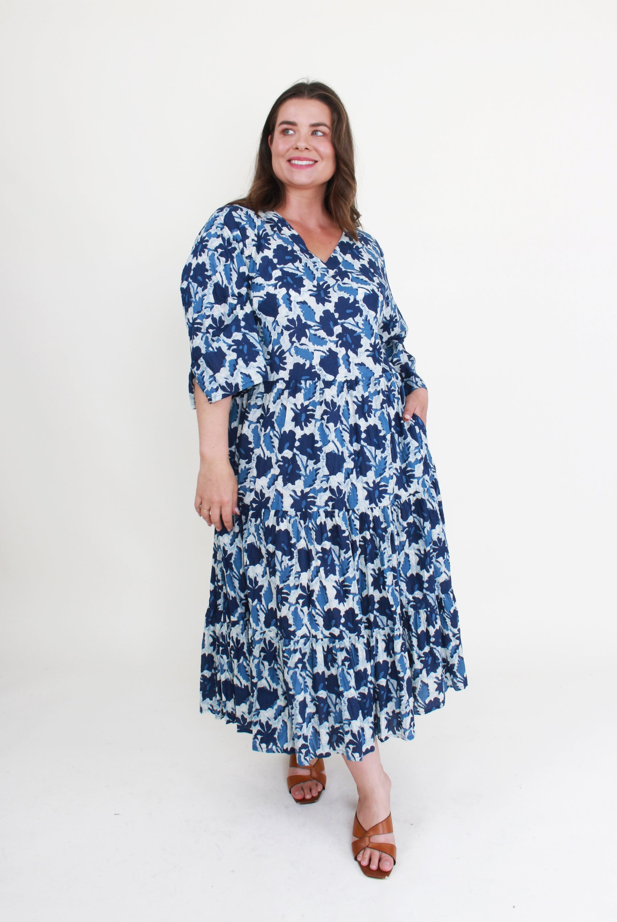 Woman wearing a blue floral dress on a white background