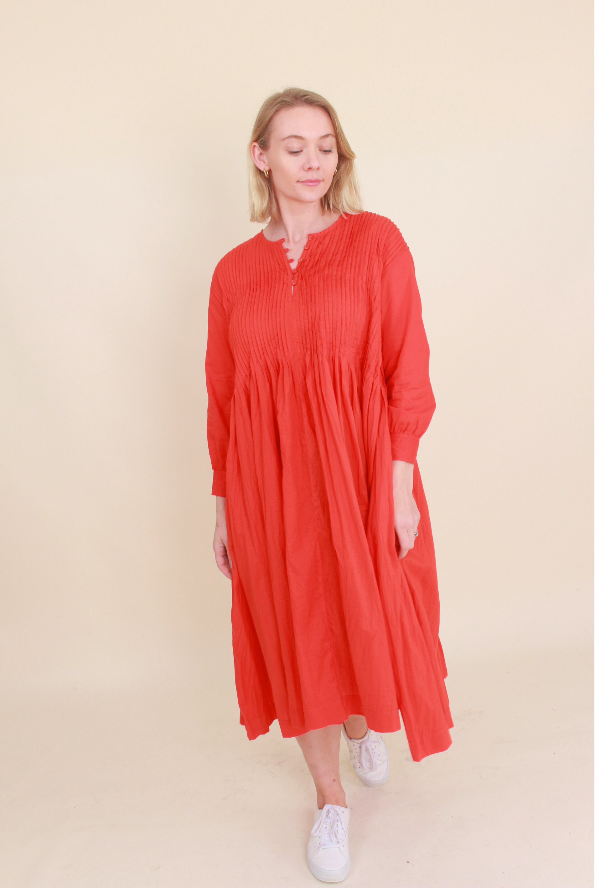 Woman wearing a red dress against a beige background