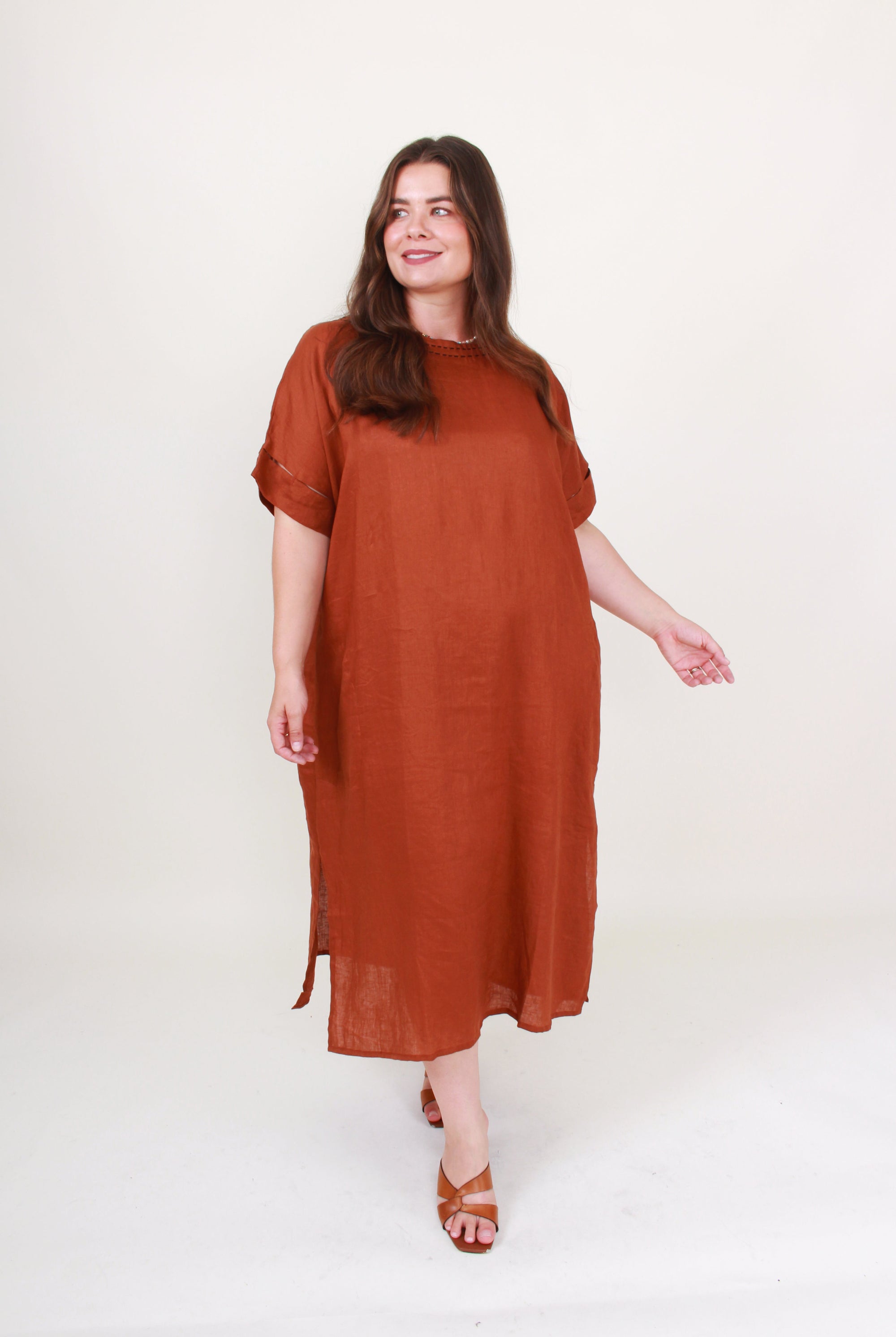Woman wearing a rust-colored dress on a white background