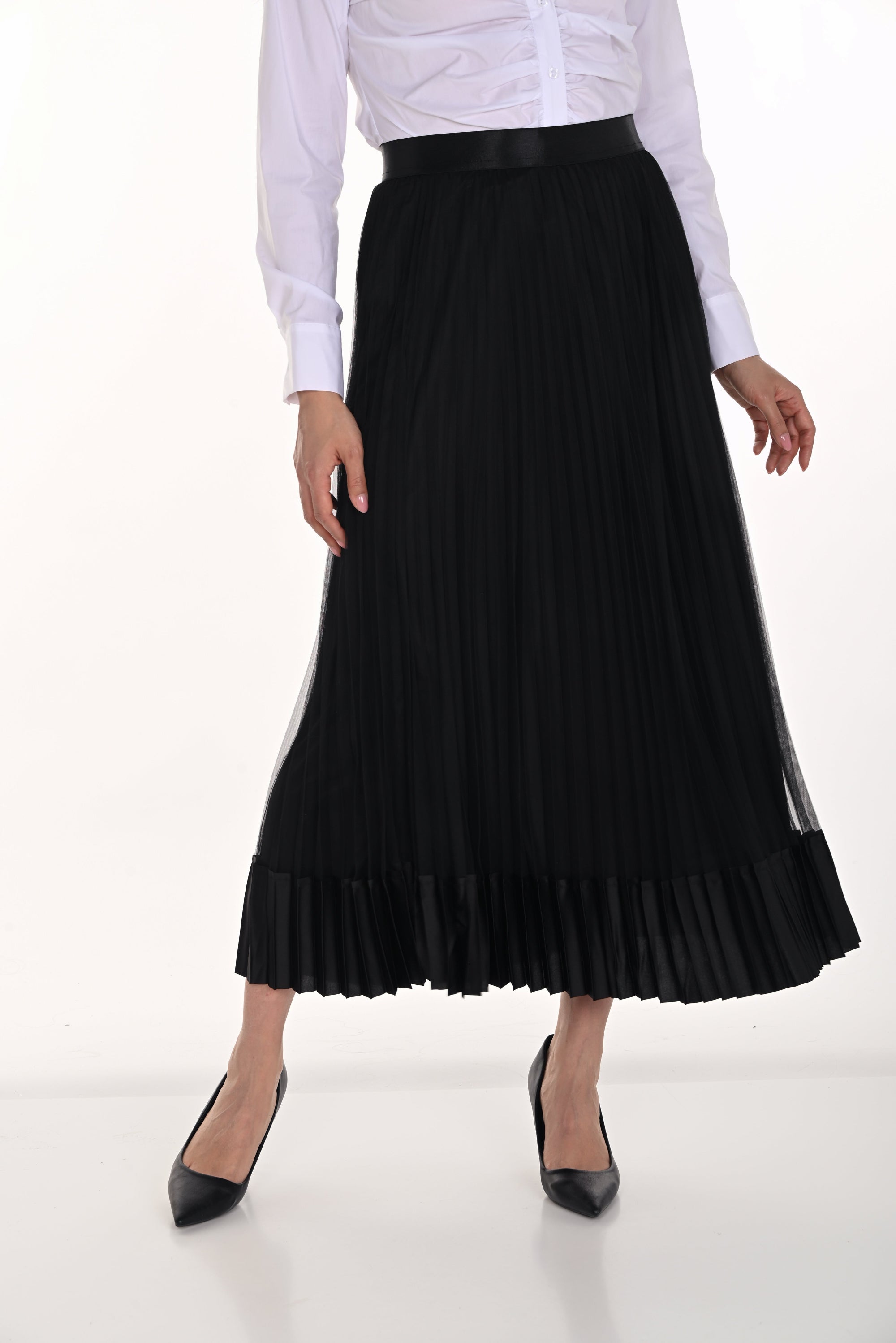 Person wearing a black pleated skirt on a white background