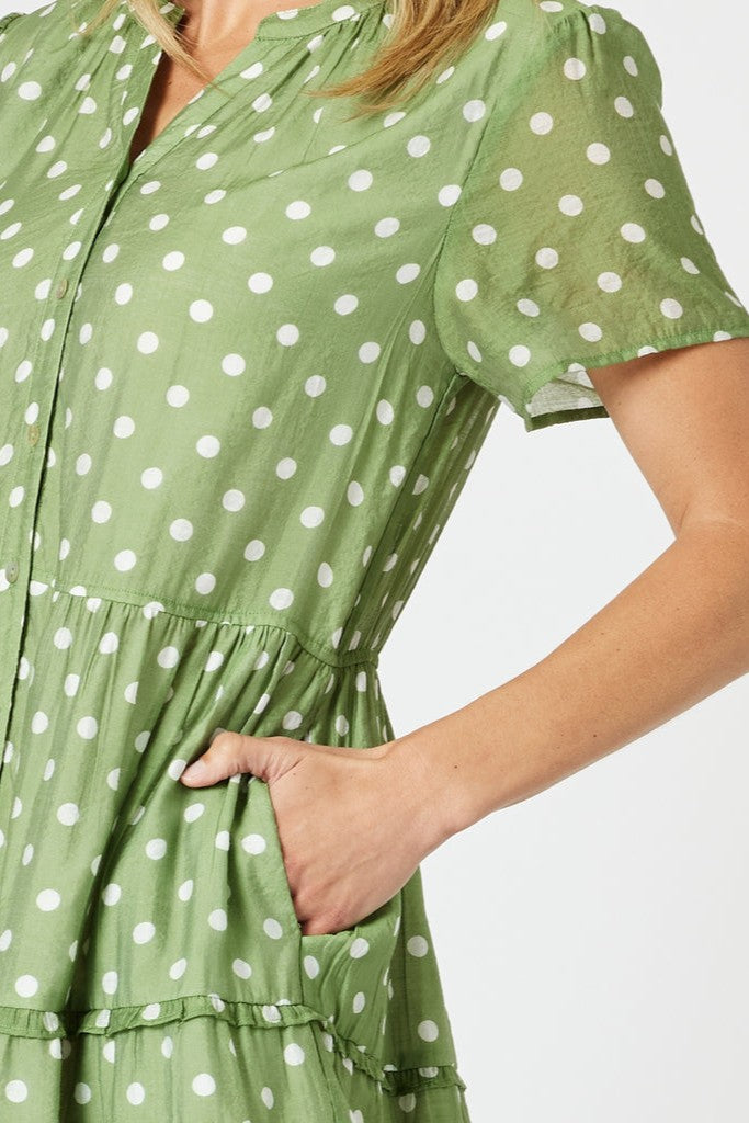 Woman wearing a green polka dot dress on a white background