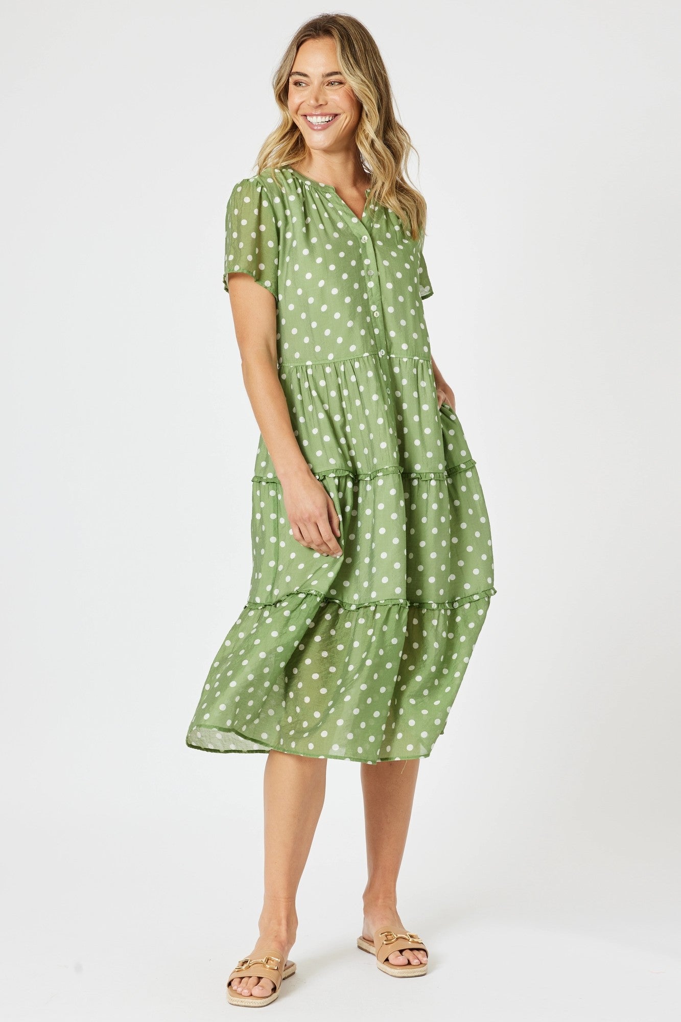 Woman wearing a green polka dot dress on a white background