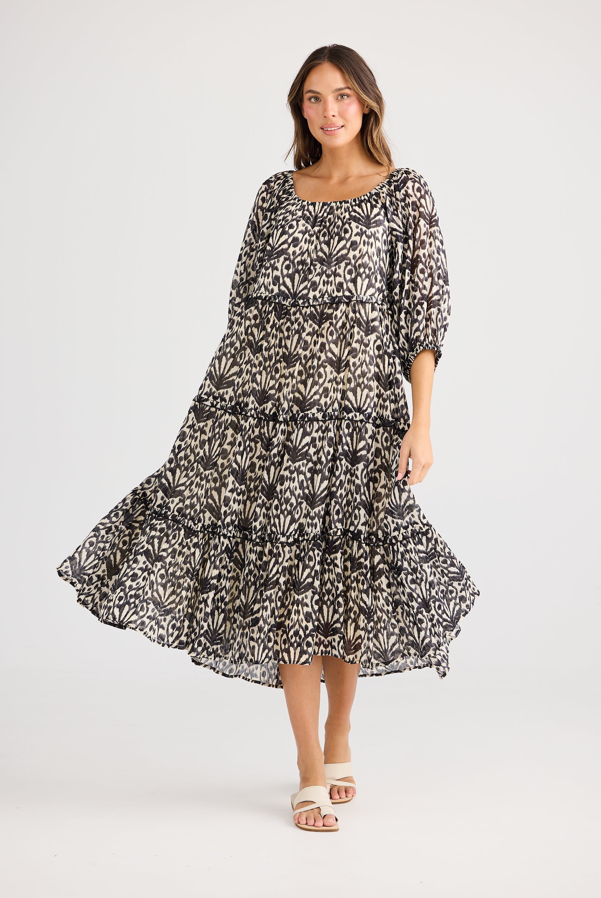 model wearing black cream long floral dress against white background