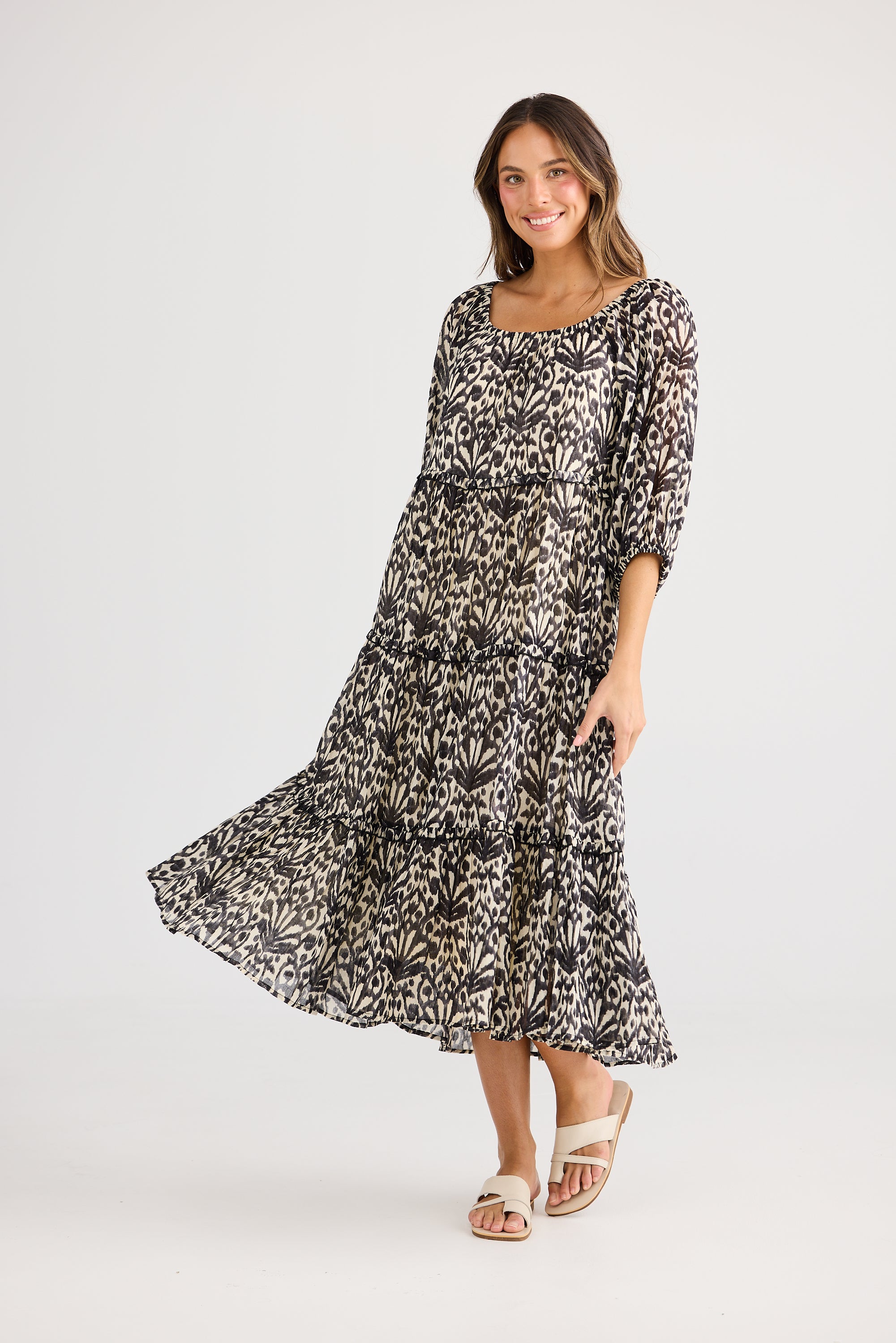 model wearing black cream long floral dress against white background