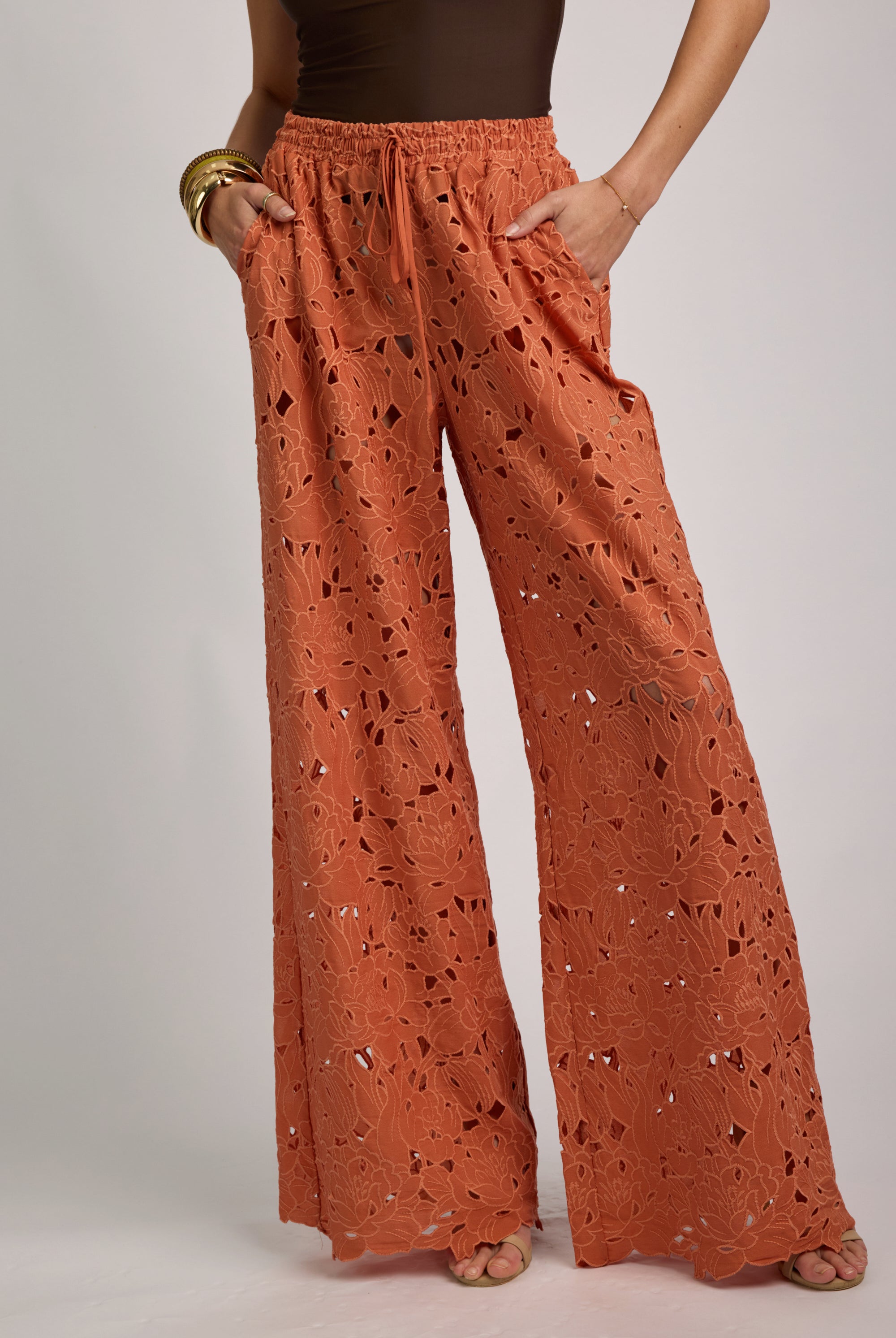 Orange lace pants worn by a person on a plain background