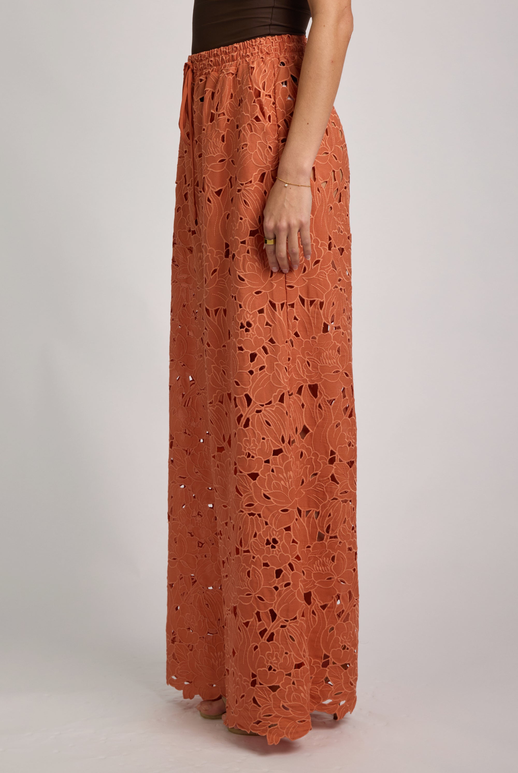 Long orange lace skirt worn by a person on a plain background