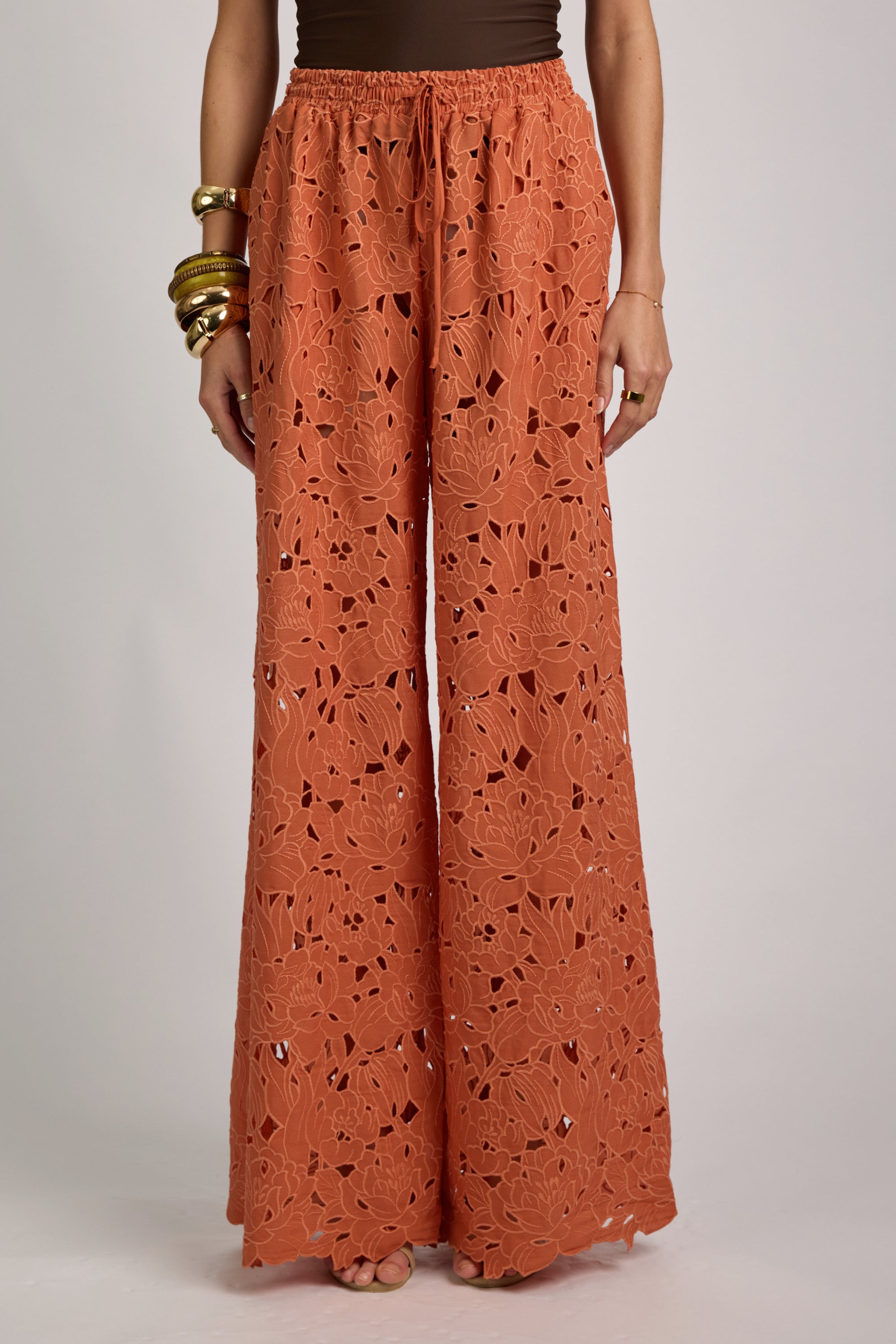 Orange lace pants worn by a person on a plain background