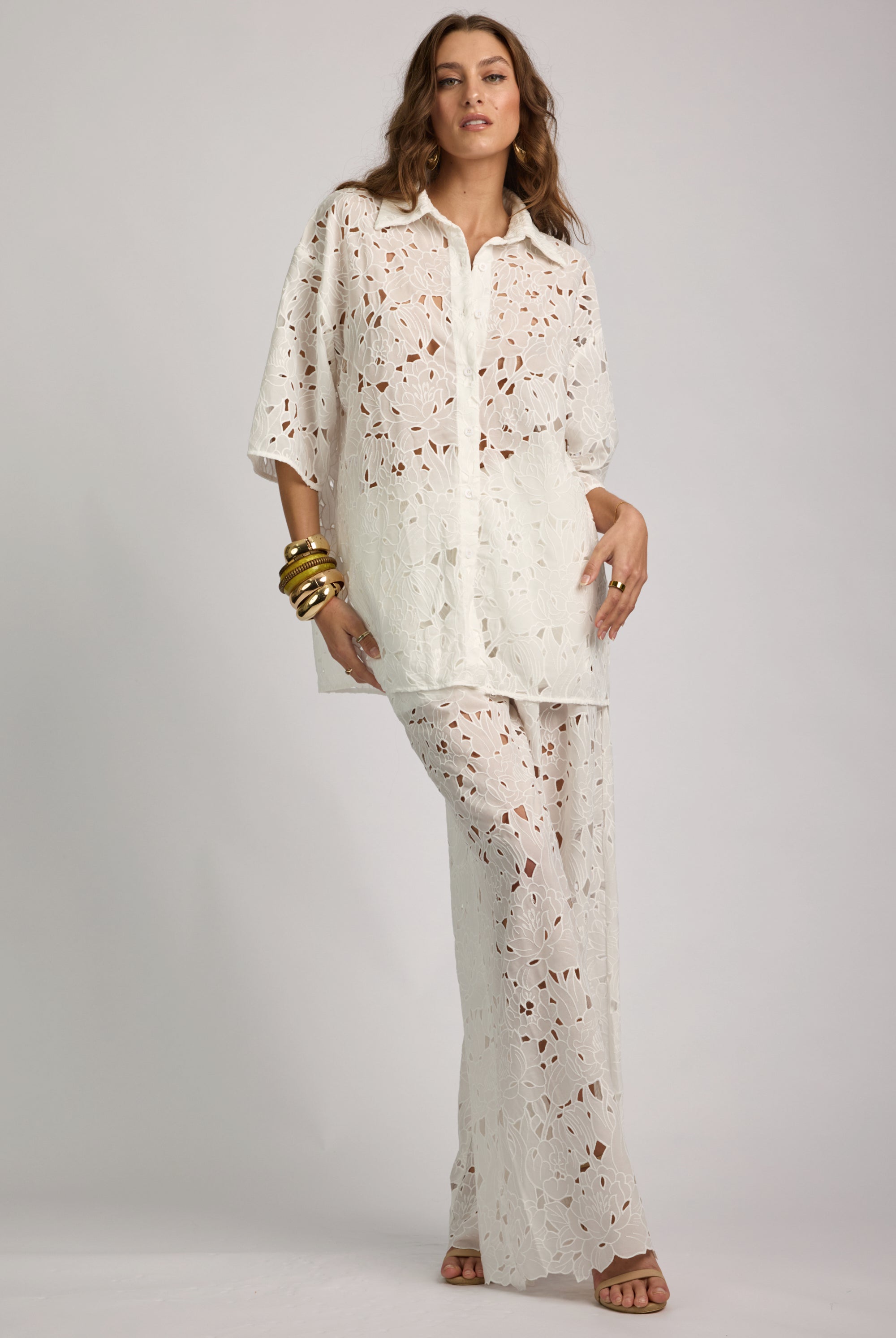 Woman wearing a white floral outfit on a gray background