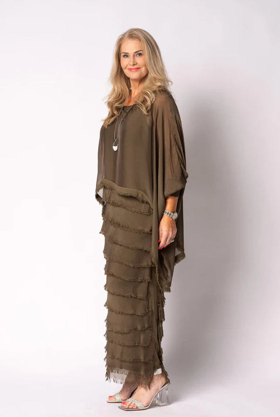 Woman wearing a long, layered moss green dress against a white background