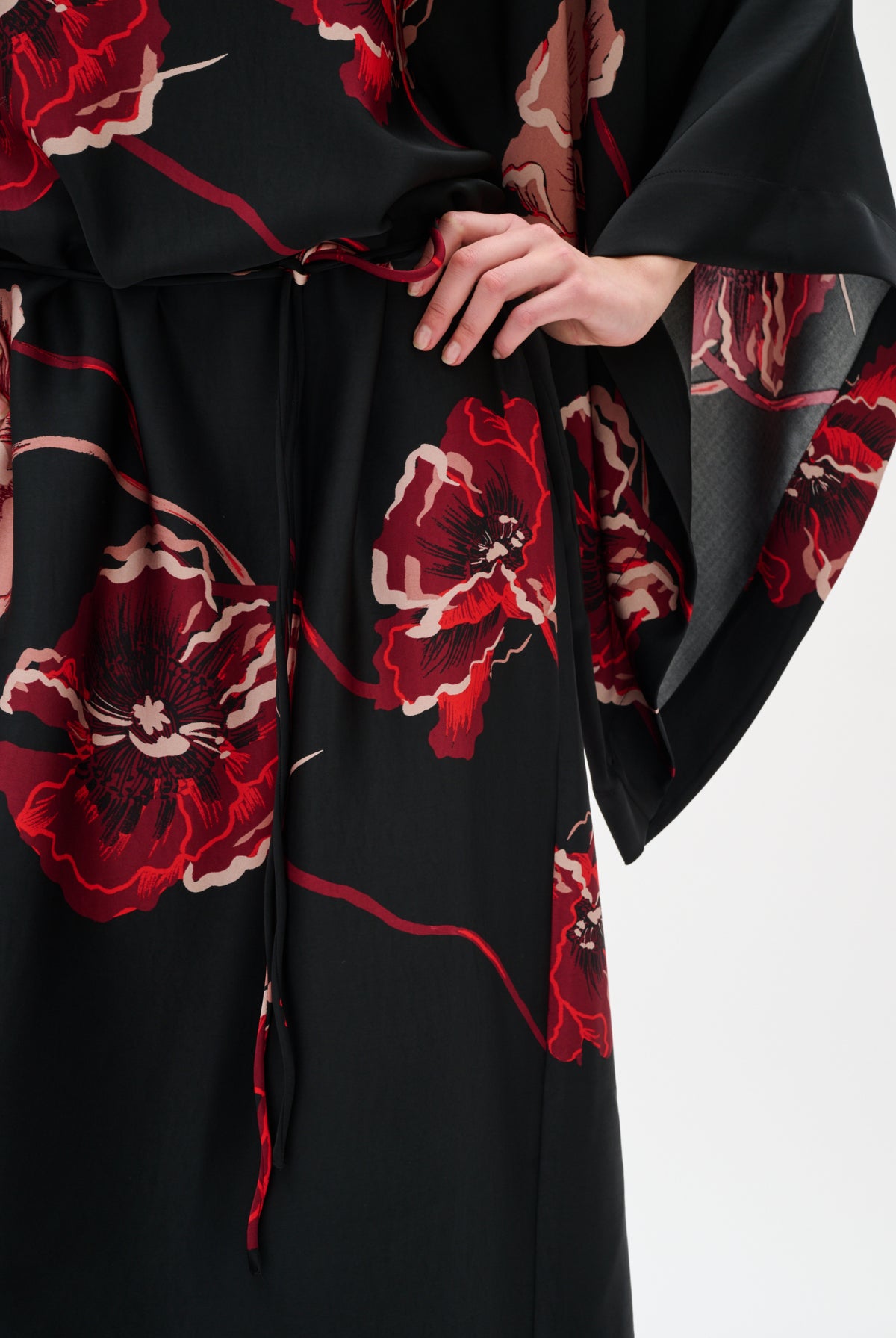 Black garment with red floral patterns on a white background close up