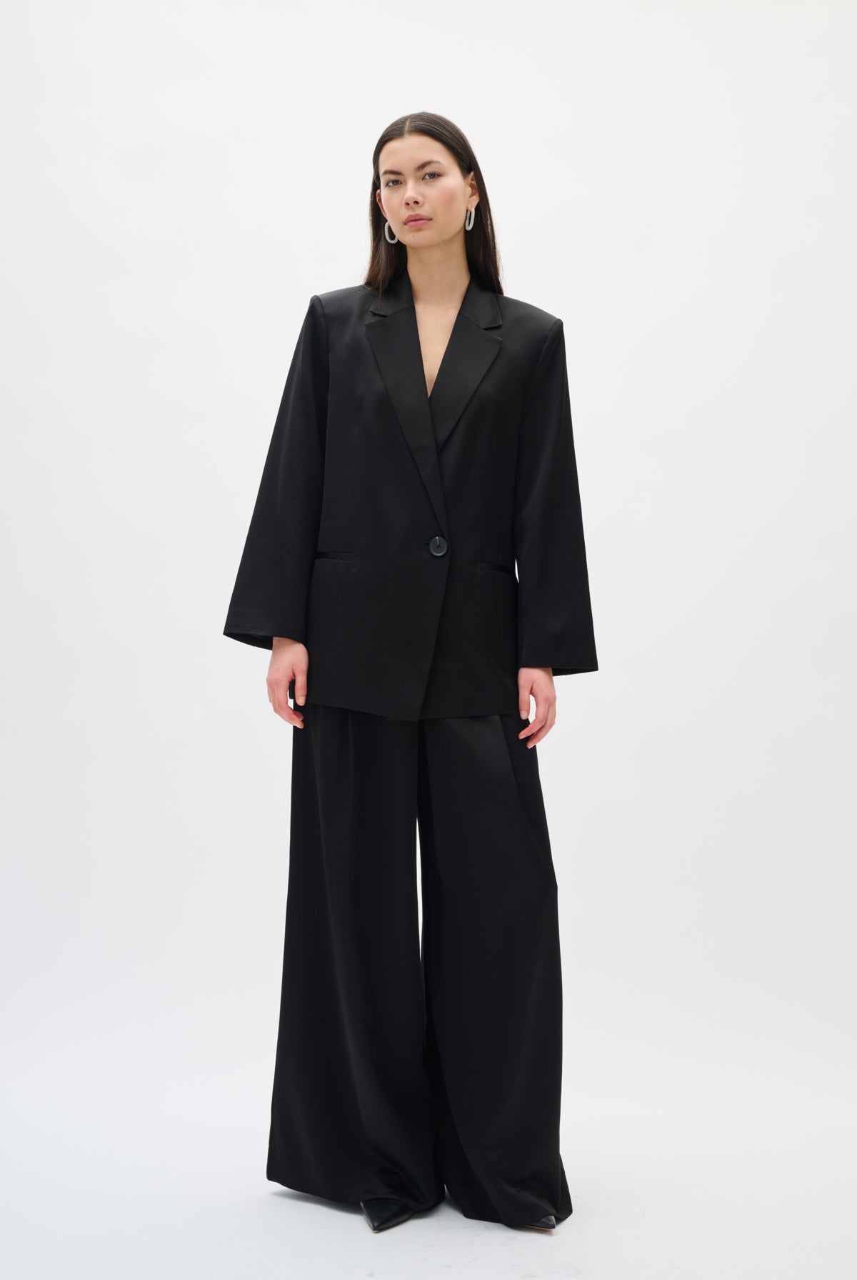 Woman wearing a black suit on a white background